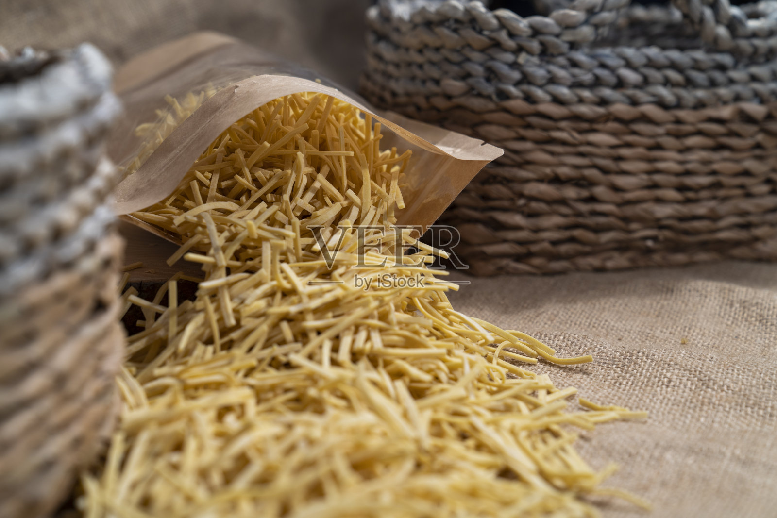 用牛皮纸包装的豆类放在柳条篮子前面照片摄影图片