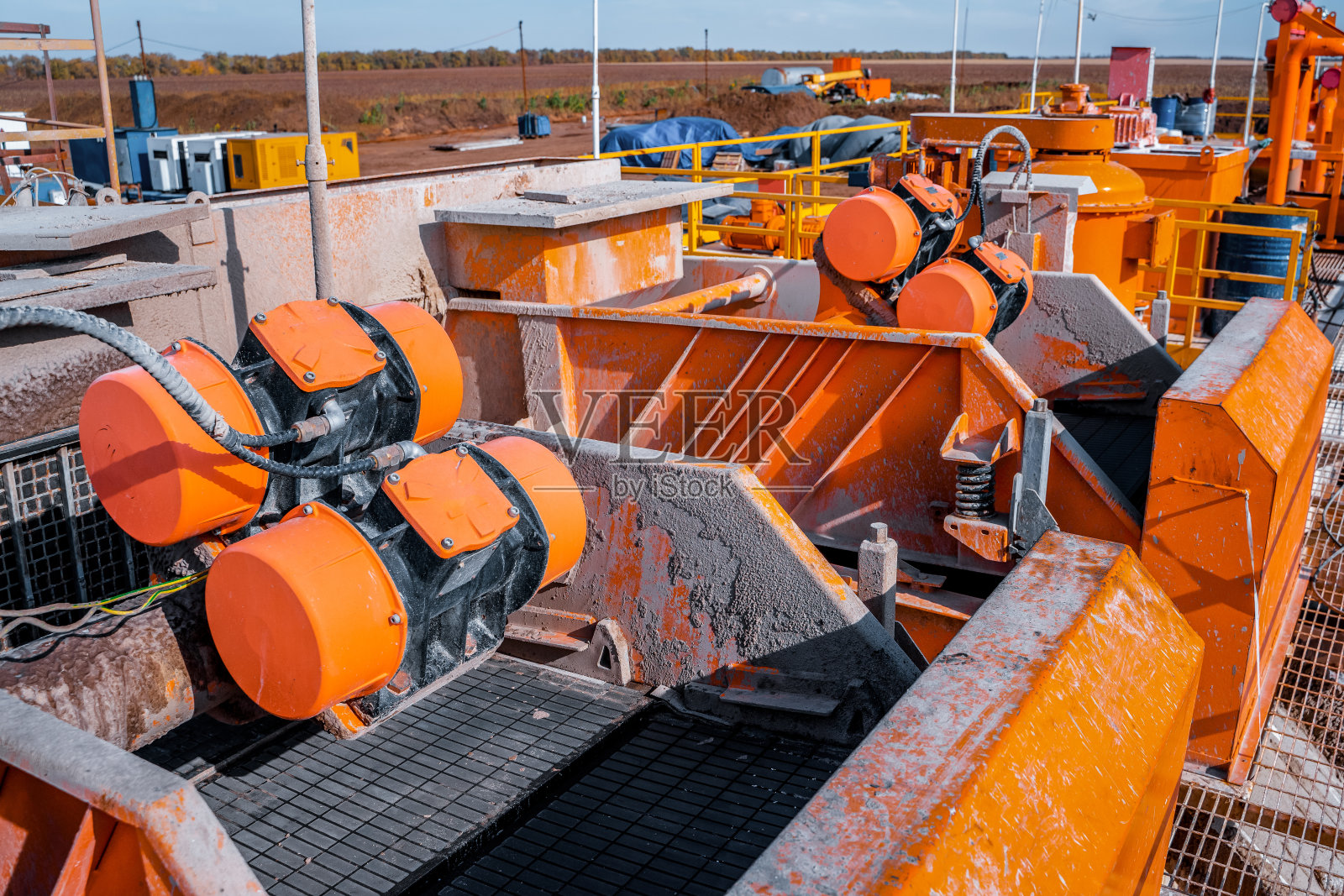 海上石油钻机上的页岩振动筛。页岩振动筛筛近视图与钻切削流出油基泥浆照片摄影图片