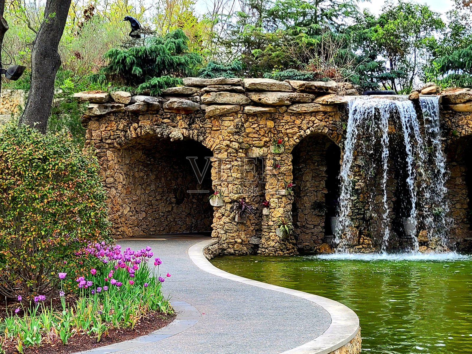 瀑布从岩石结构流入池塘照片摄影图片