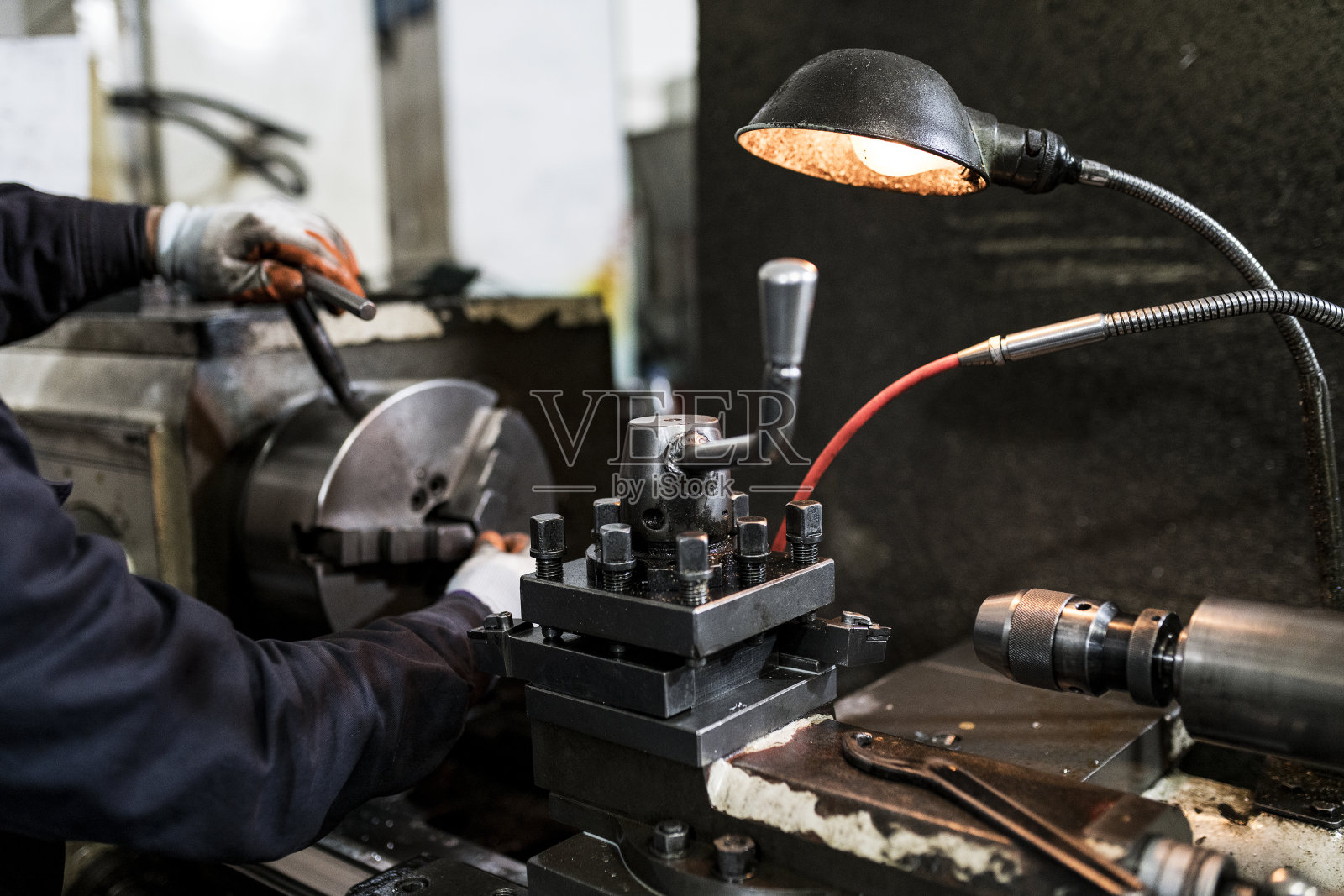 车工在车床上磨制铁棒的一部分。照片摄影图片