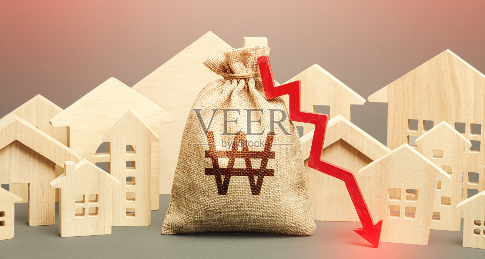 市住宅和韩元钱袋上有一个红色的向下箭头。购房需求低。较低的按揭利率。出租公寓价格下跌。低成本房地产。照片摄影图片