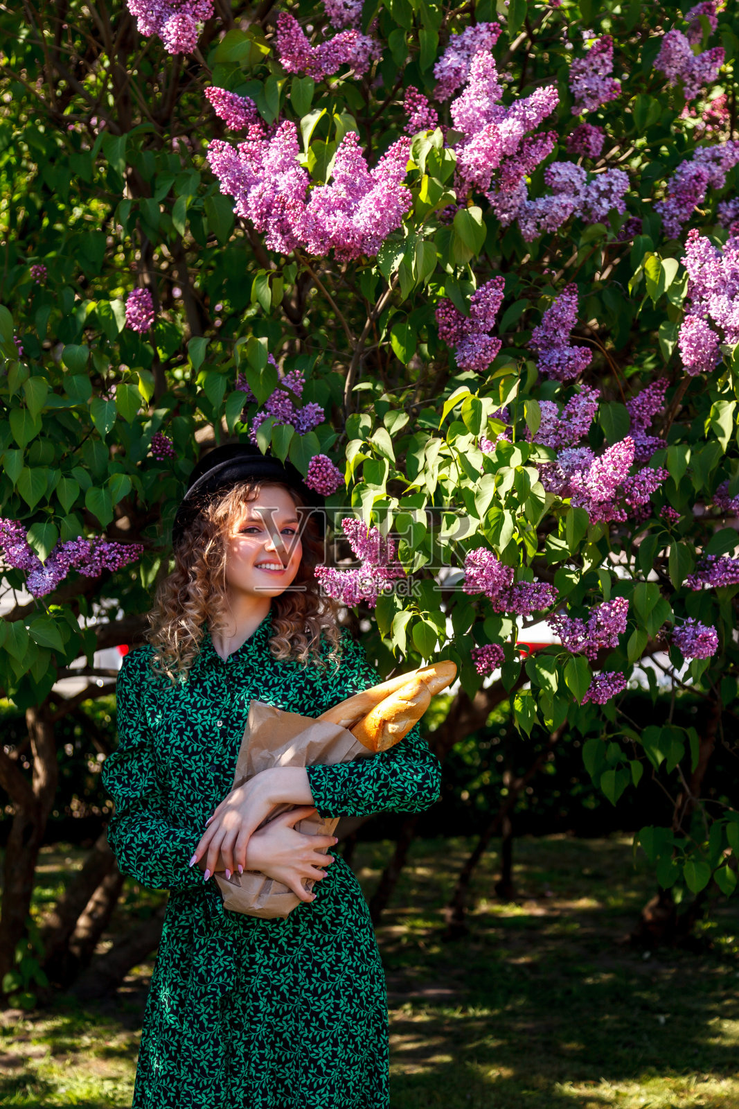 漂亮的女孩穿着法国风格的衣服，手里拿着法式长棍，穿着淡紫色的衣服照片摄影图片