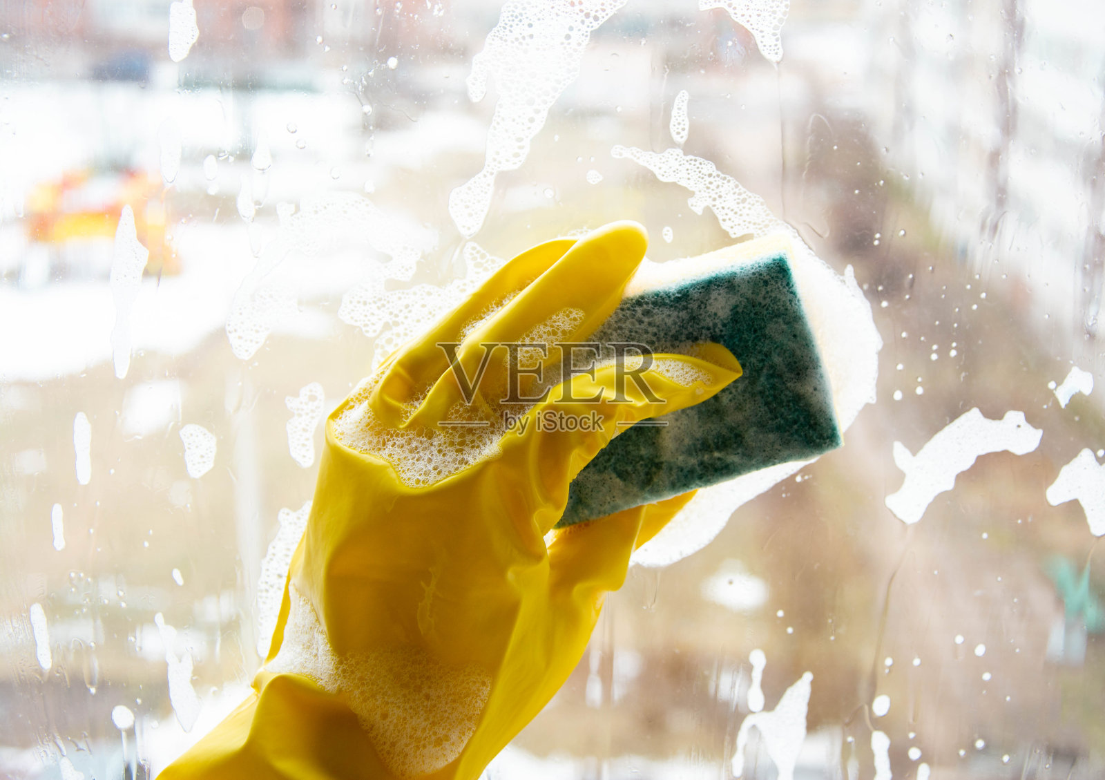 春天用洗涤剂和海绵清洗脏的窗玻璃。家里清洁照片摄影图片