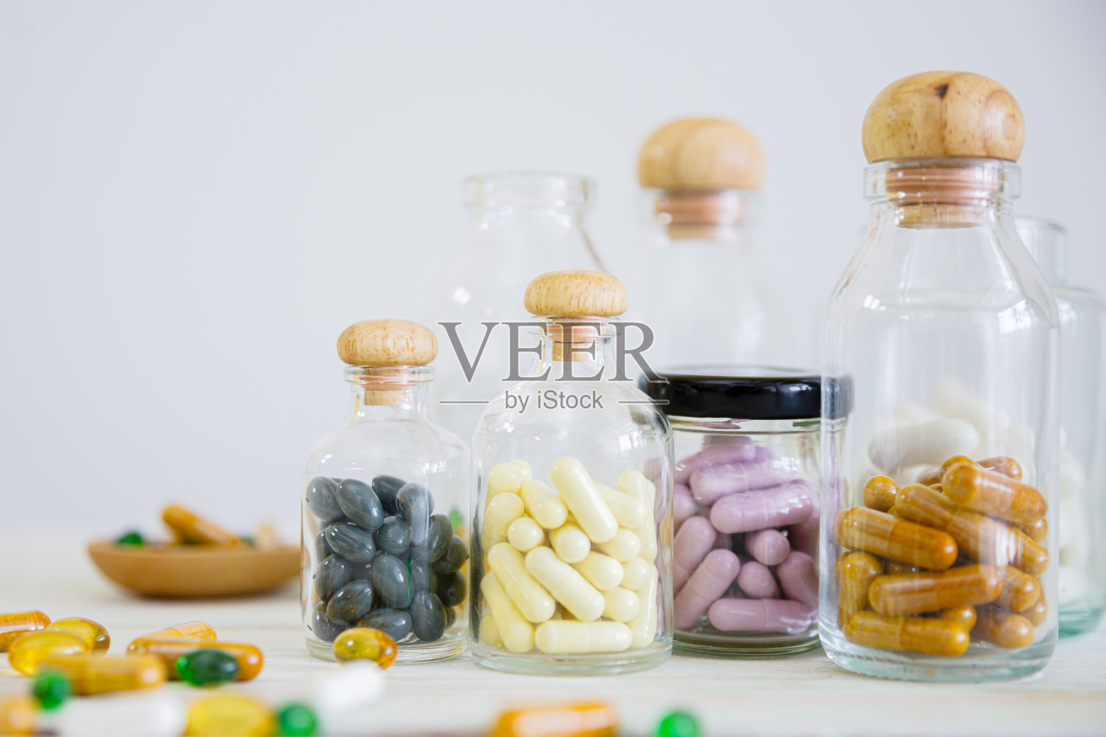 把装在木桌上的玻璃瓶里的药片和药片放好。医学概念、病毒治疗、医疗保健。照片摄影图片