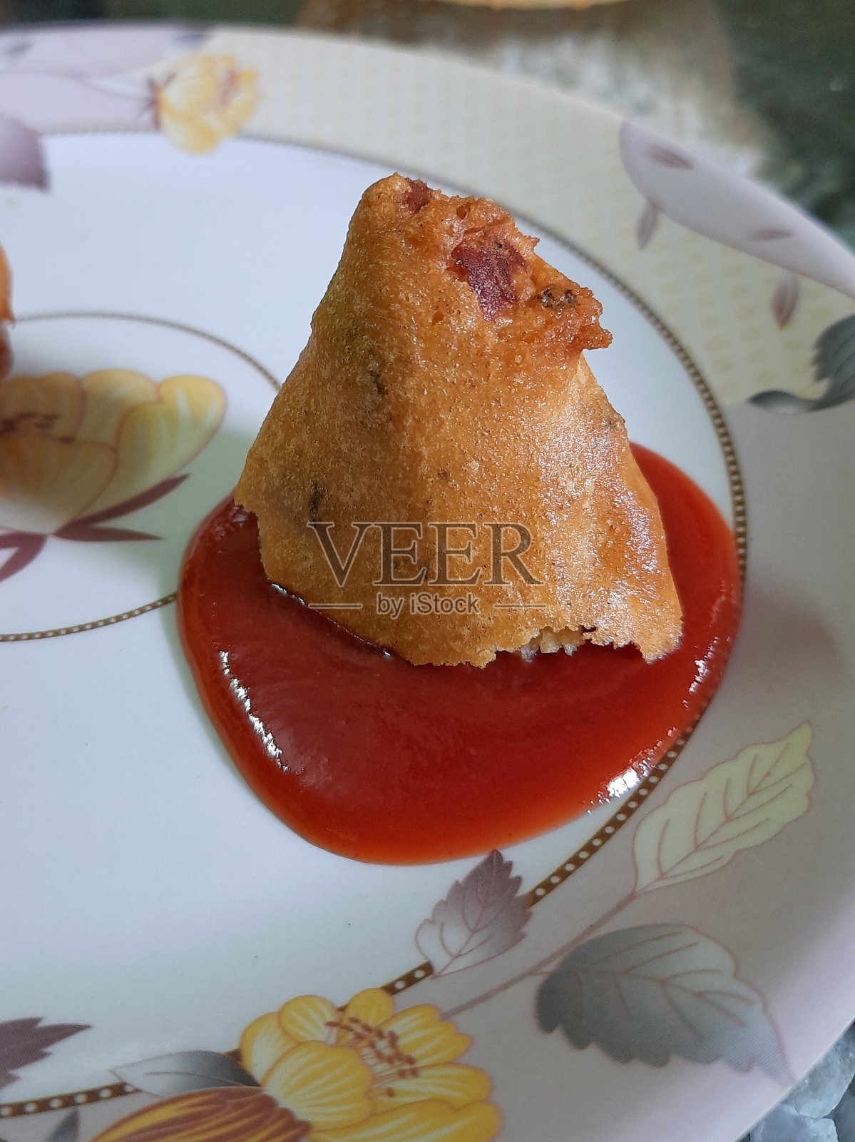 加番茄酱的油炸印度小吃。照片摄影图片