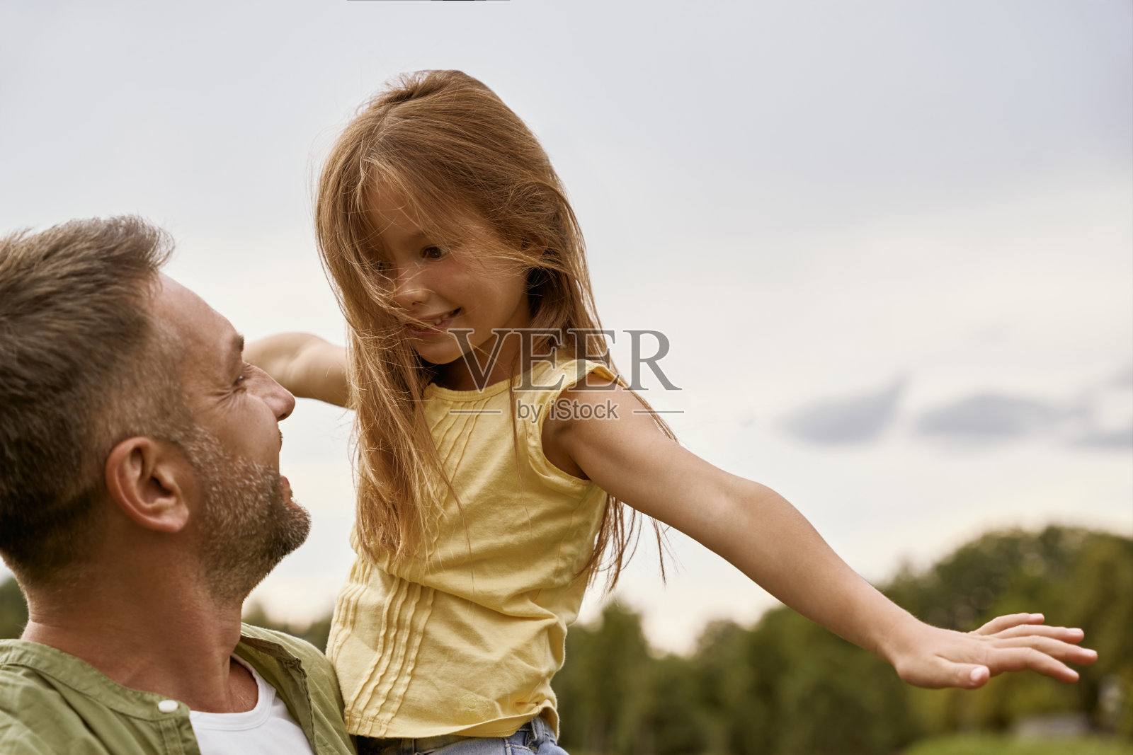 家庭时间。在一个温暖的夏日里，快乐的小女孩和她慈爱善良的父亲一起游玩公园，一起感觉很快乐照片摄影图片