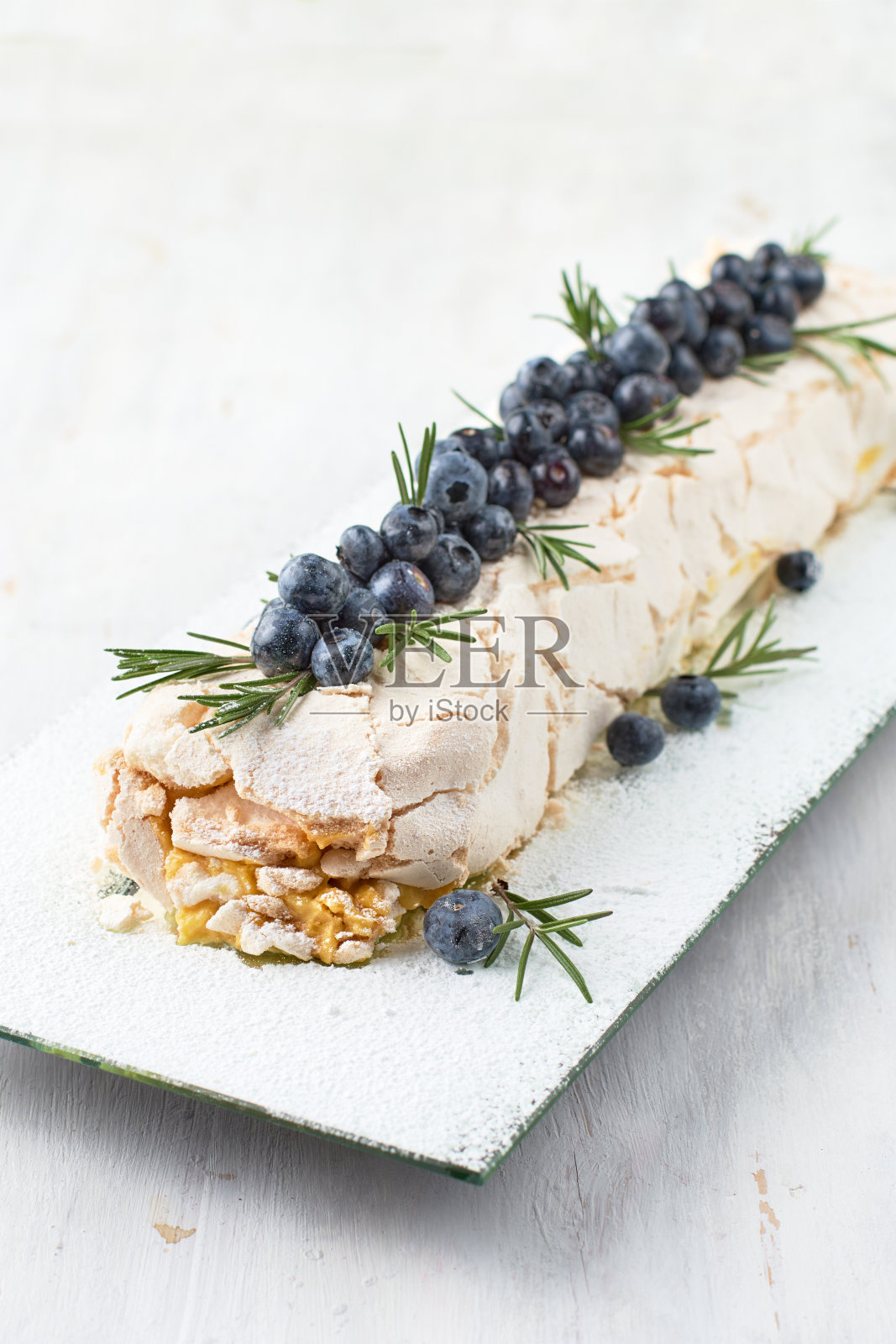 蛋白酥甜点巴芙洛娃蛋糕上有新鲜的浆果，上面是一个轻木制的背景。照片摄影图片