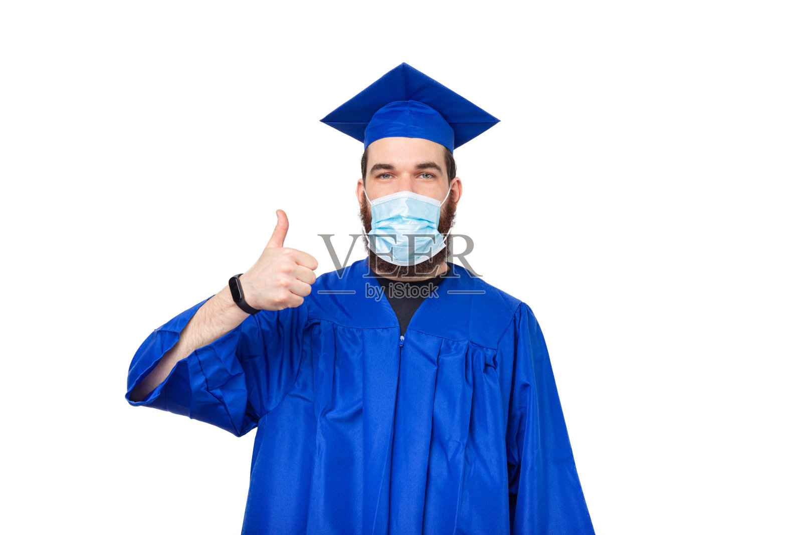 照片中的男学生竖起大拇指，戴着毕业帽和学士照片摄影图片