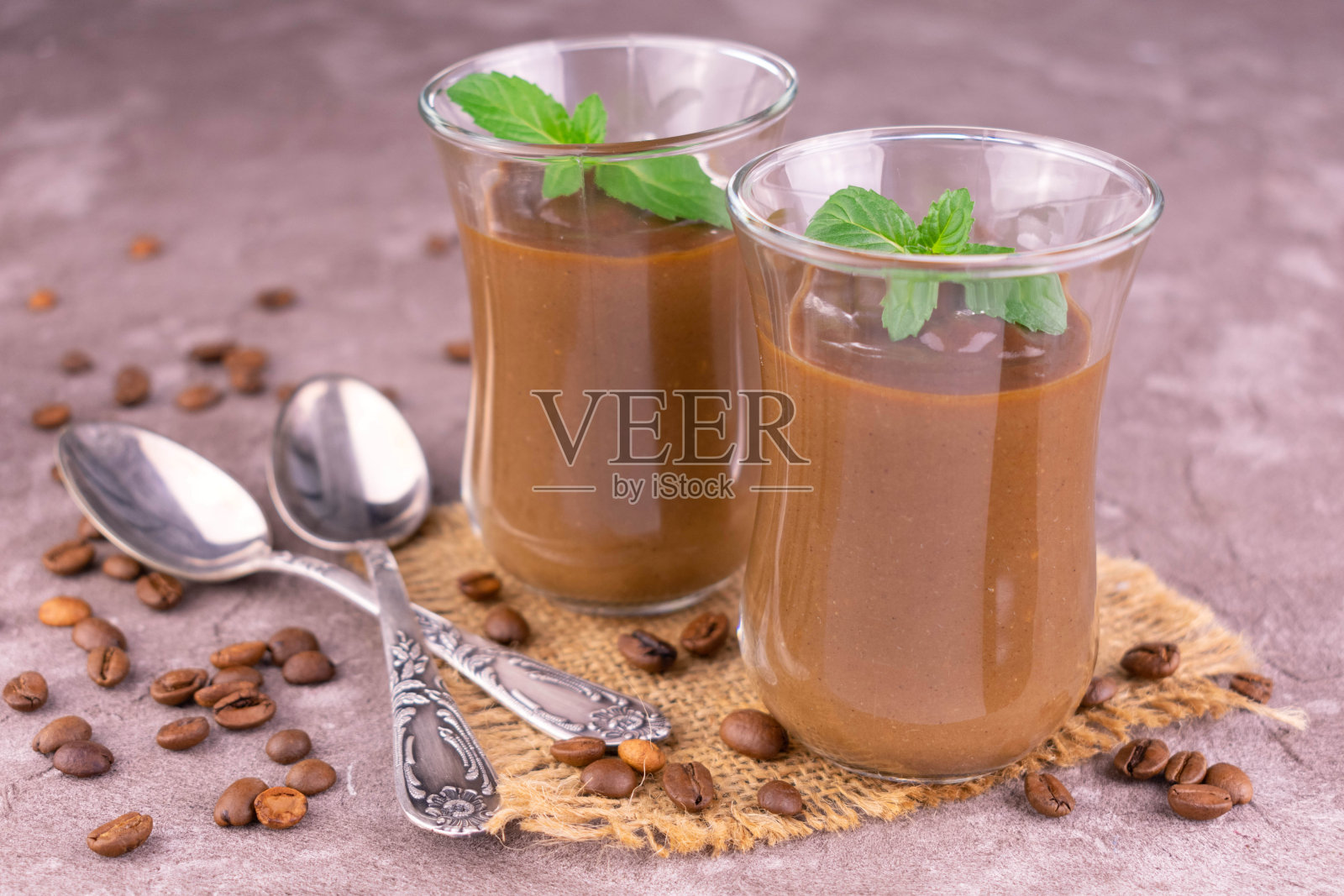 在灰色的背景上装饰有薄荷的两款甜点咖啡慕斯。特写镜头。照片摄影图片