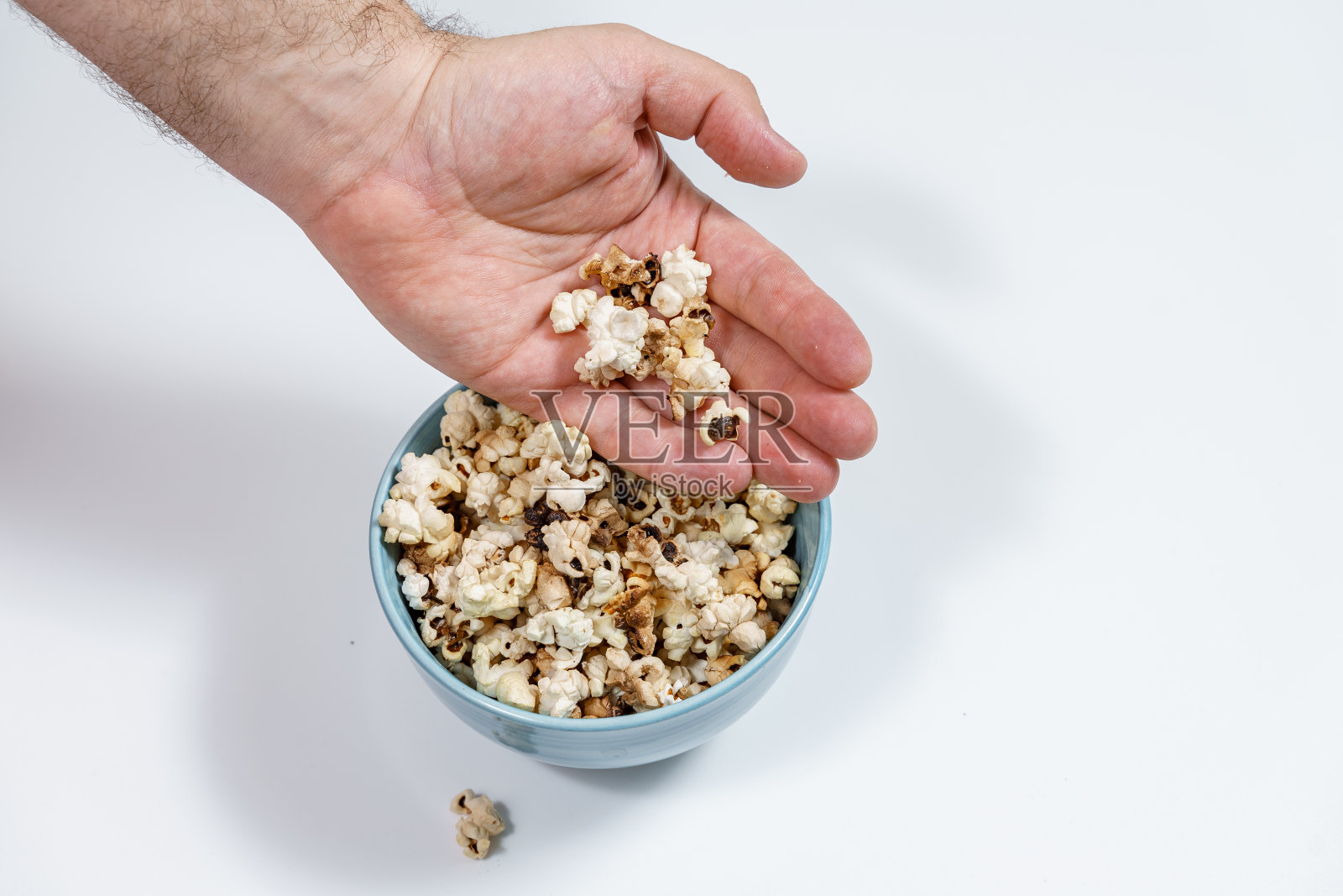 蓝色杯子里的黑色爆米花照片摄影图片