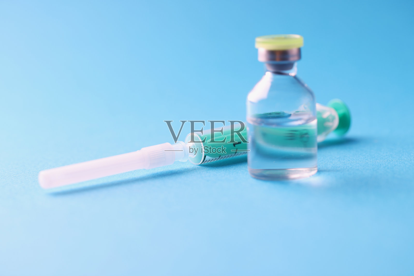玻璃罐与药品和无菌注射器的特写在蓝色背景照片摄影图片