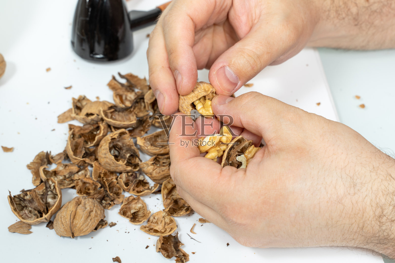 男人皮核桃。手关闭。照片摄影图片