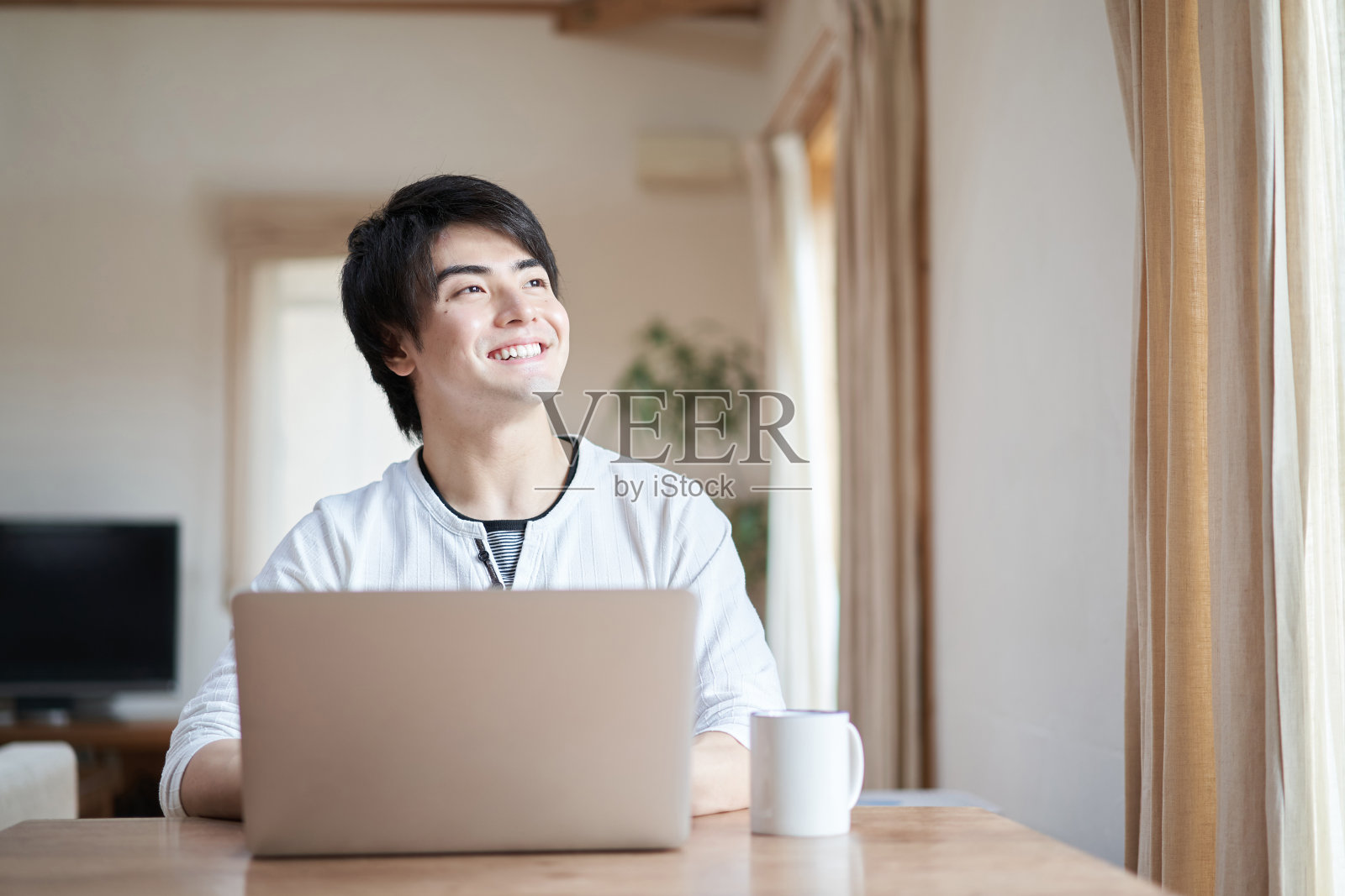 一个亚洲人在客厅里操作电脑照片摄影图片