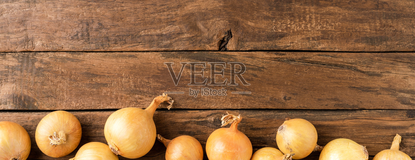 洋葱在质朴的木制背景与copyspace。前视图。横幅照片摄影图片