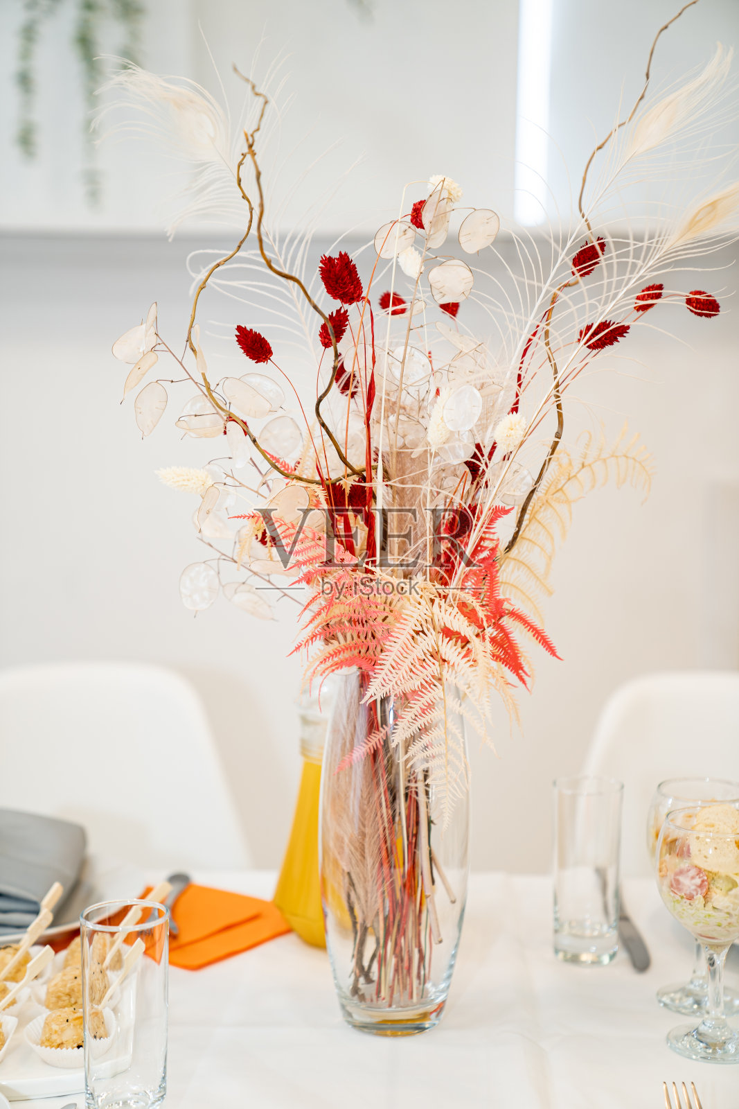 装着一束漂亮干花的玻璃花瓶。照片摄影图片