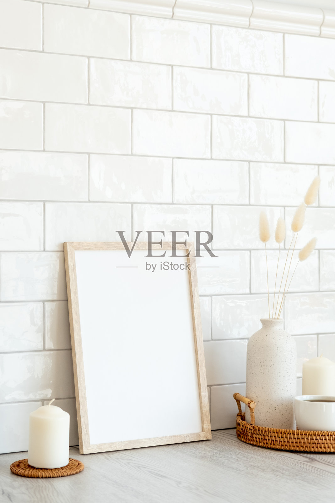 空白相框模型和家庭装饰桌上。背景是白色瓷砖砖。简约斯堪的纳维亚风格的室内设计照片摄影图片