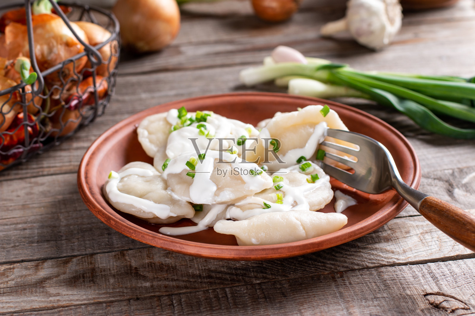 饺子，盛满土豆泥的盘子放在木桌上。Varenyky, vareniki, pierogi，火锅包馅。素食菜。照片摄影图片