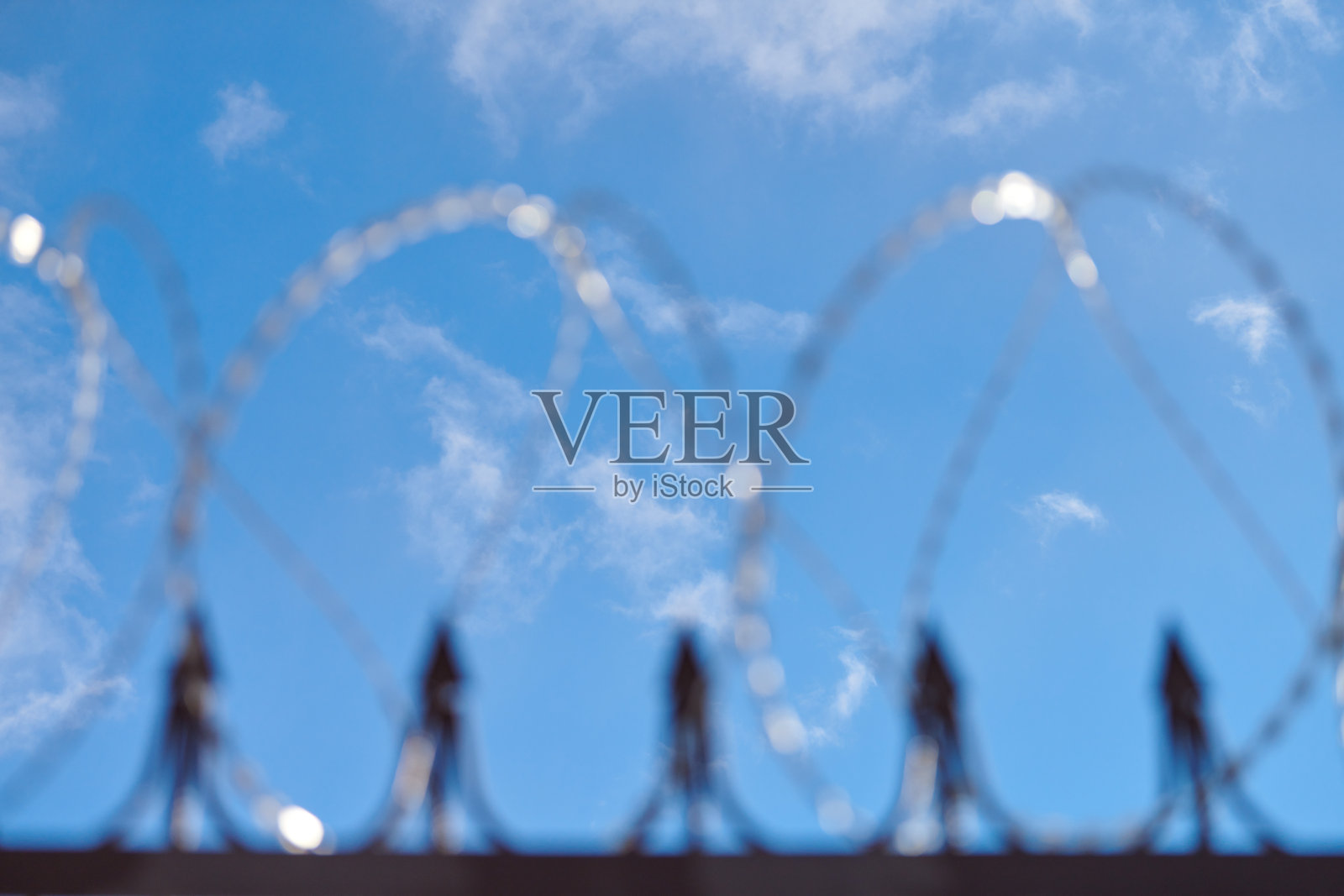 栅栏上有模糊的铁丝网，栅栏上有倒钩的钢格栅照片摄影图片