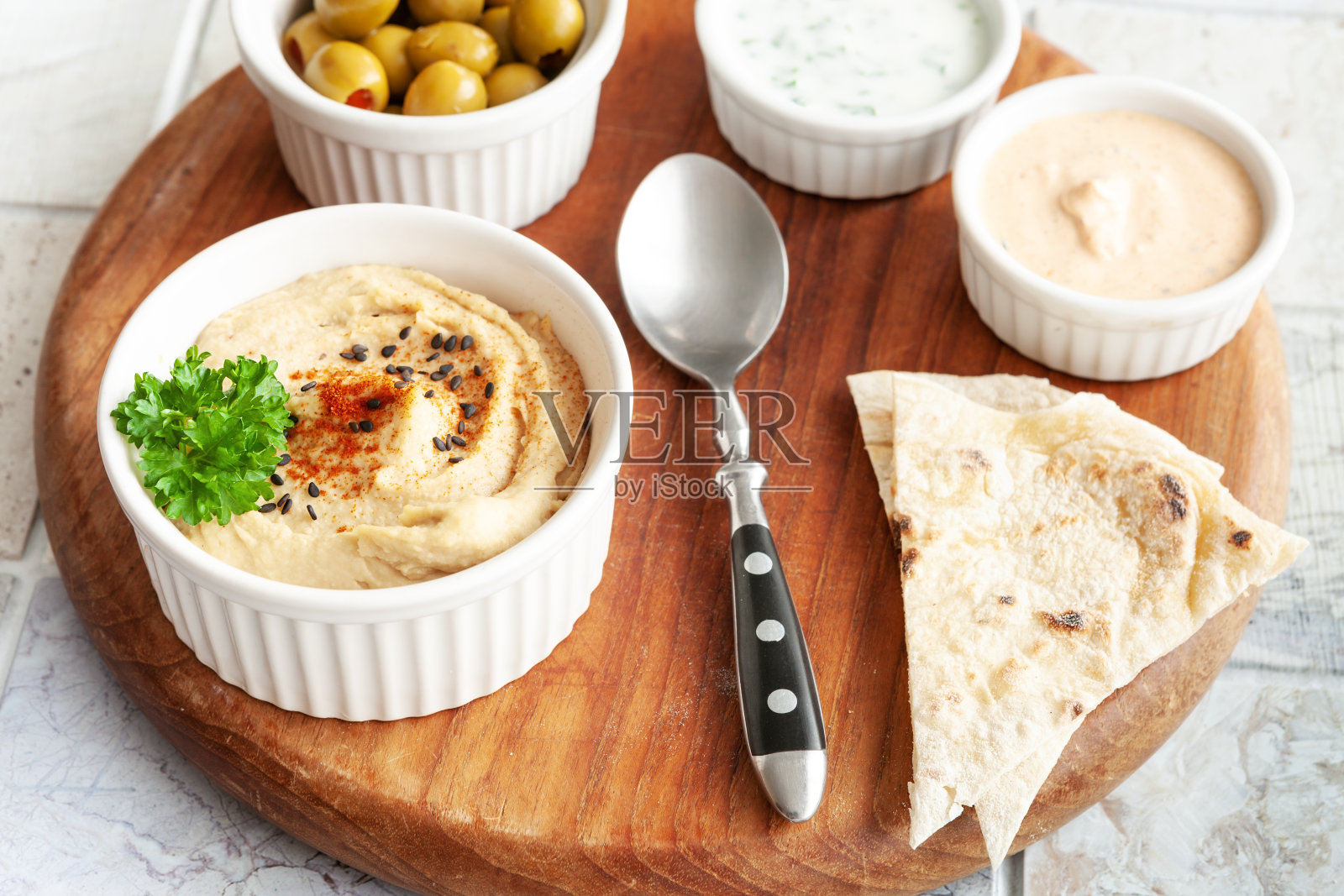 一碗鹰嘴豆泥，传统的犹太，阿拉伯，中东食物，鹰嘴豆与深和皮塔饼在瓷砖背景。特写，选择性聚焦照片摄影图片