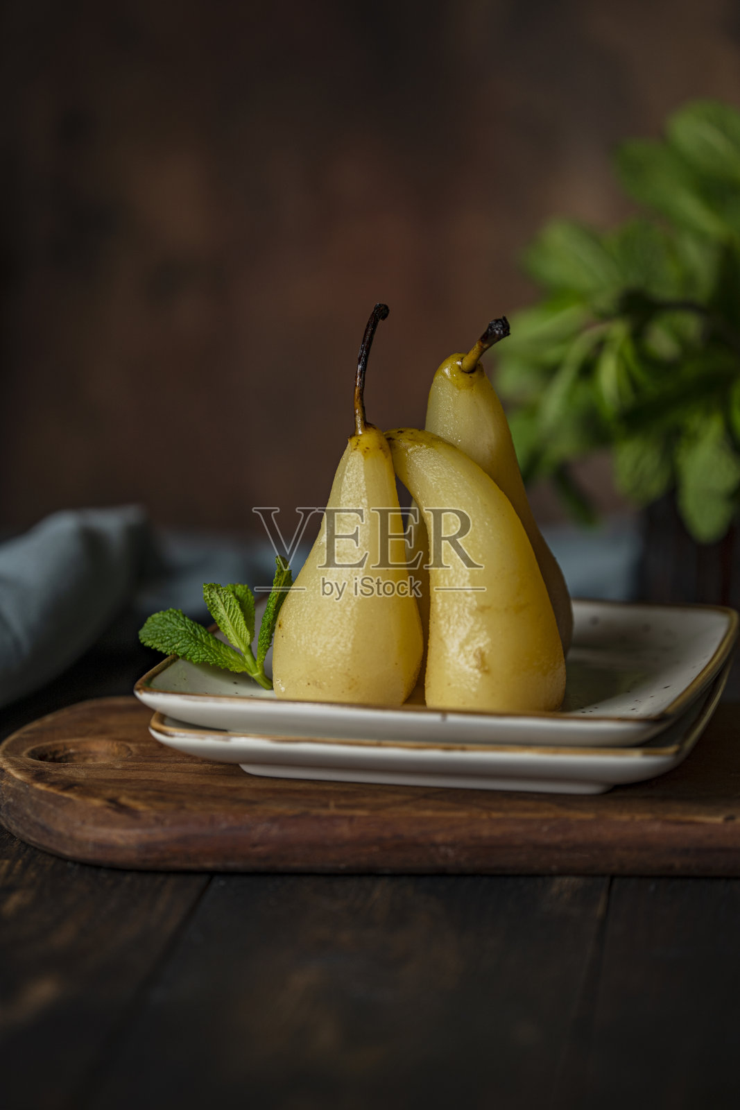 水煮或煮熟的梨子在糖浆，棕色的乡村木背景。照片摄影图片