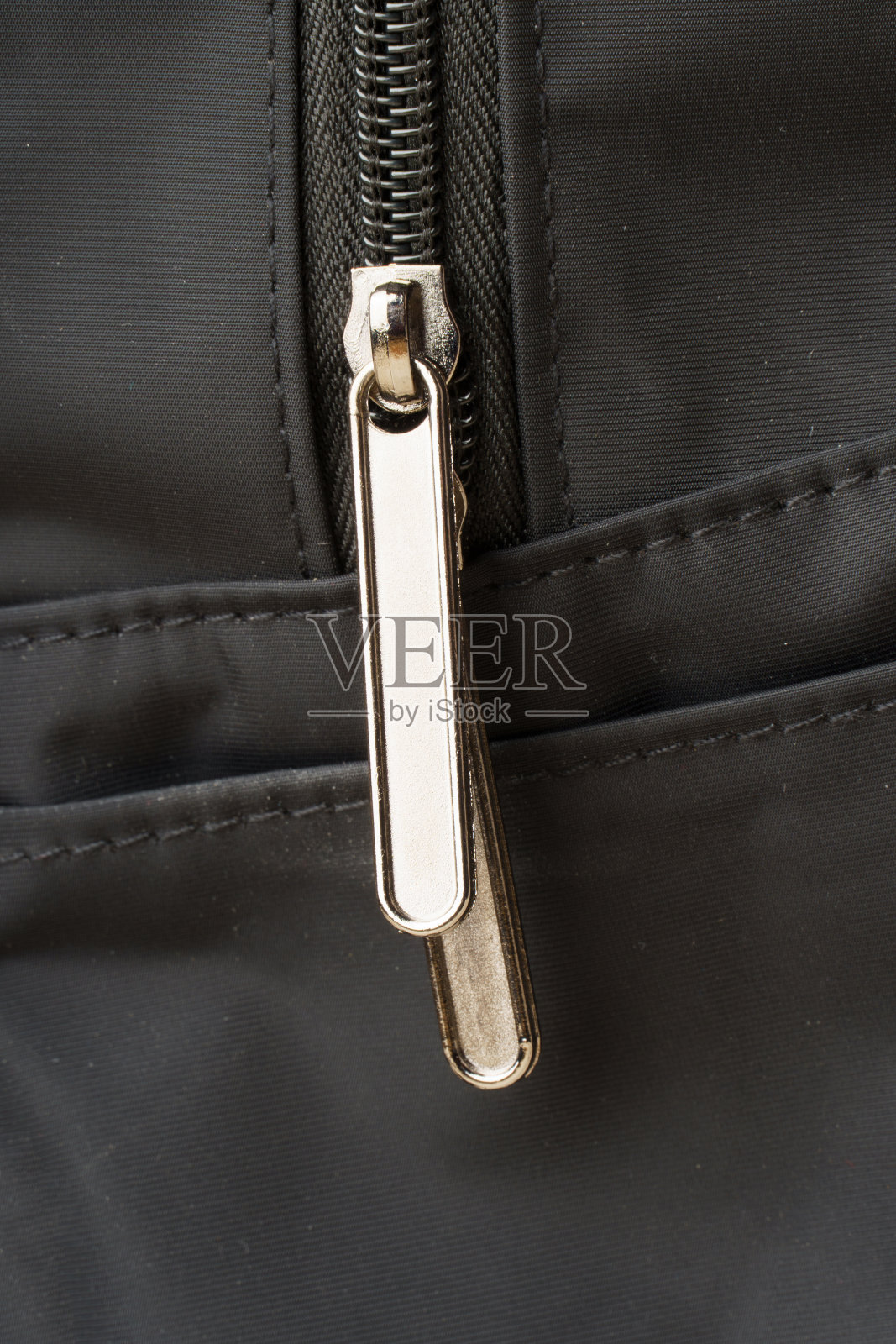 拉链上黑色面料。一个蛇扣的特写照片摄影图片