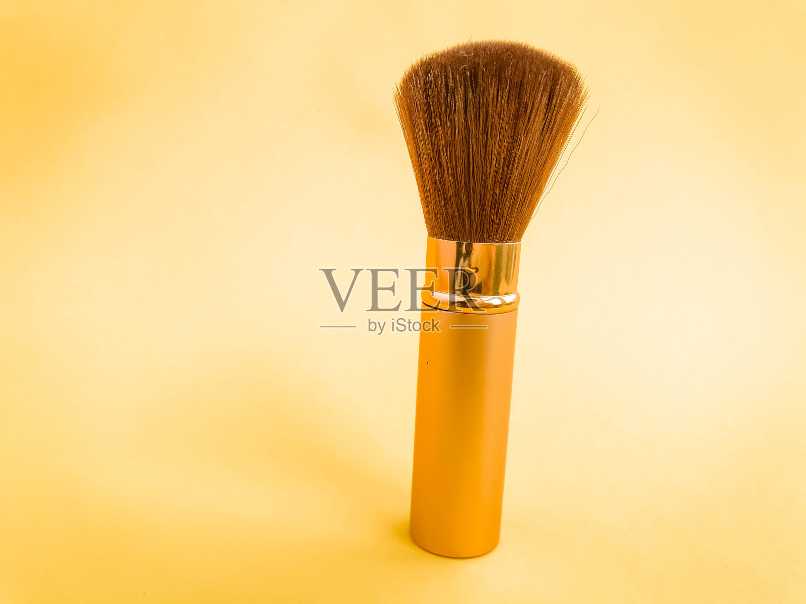 用化妆刷在白色的背景上涂上散粉照片摄影图片