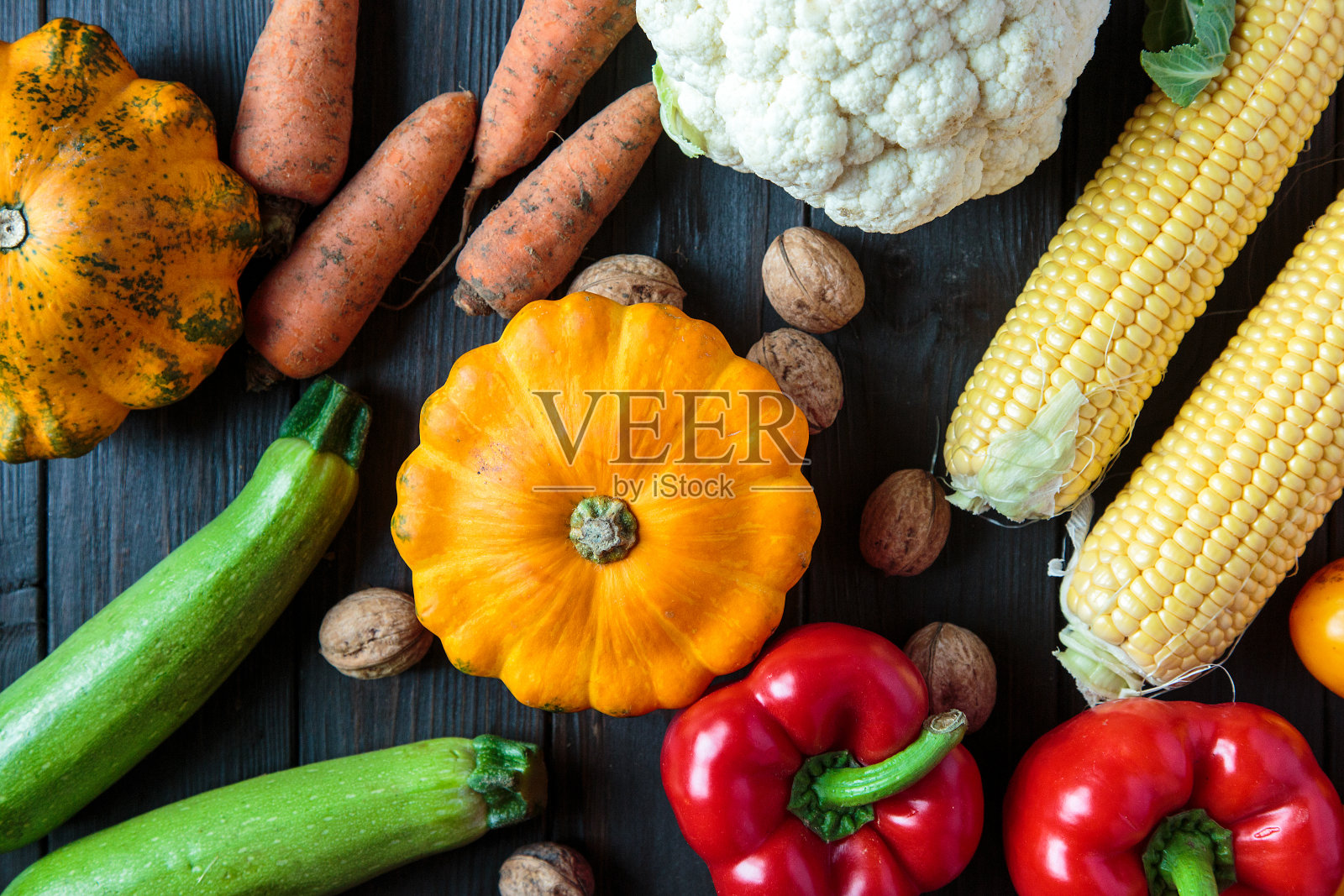 感恩节的蔬菜放在棕色的桌子上。秋玉米，胡椒，南瓜。健康食品,素食主义。新鲜蔬菜木质背景，俯视图。照片摄影图片