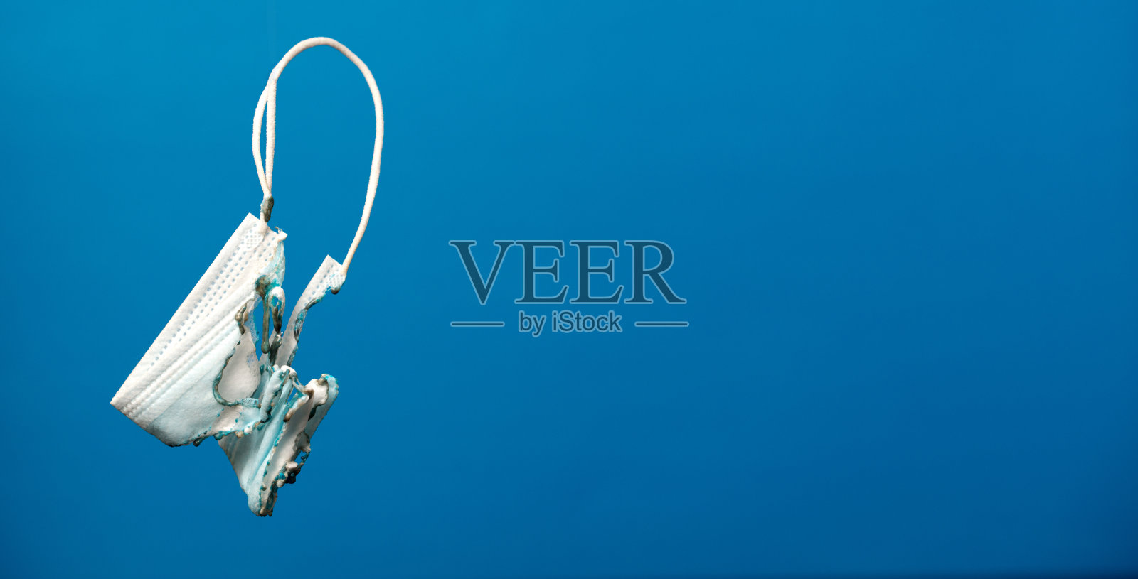 外科口罩烧伤，蓝色背景。照片摄影图片