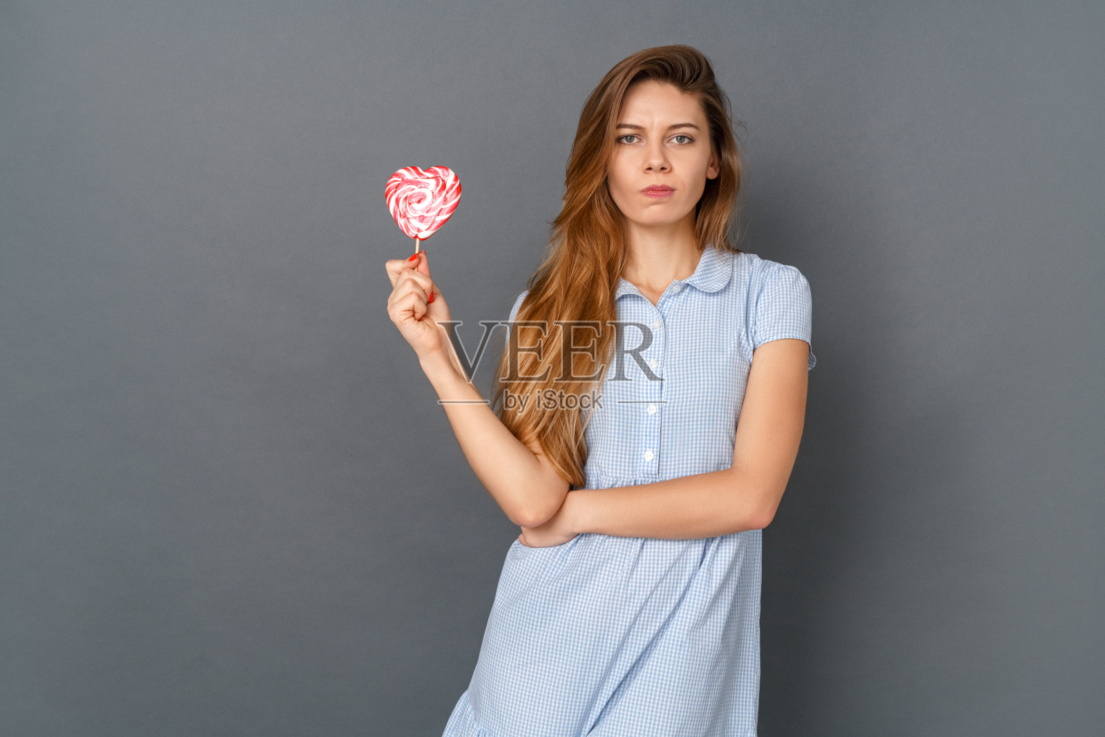 年轻女子在服装工作室孤立对灰色与棒棒糖有关照片摄影图片