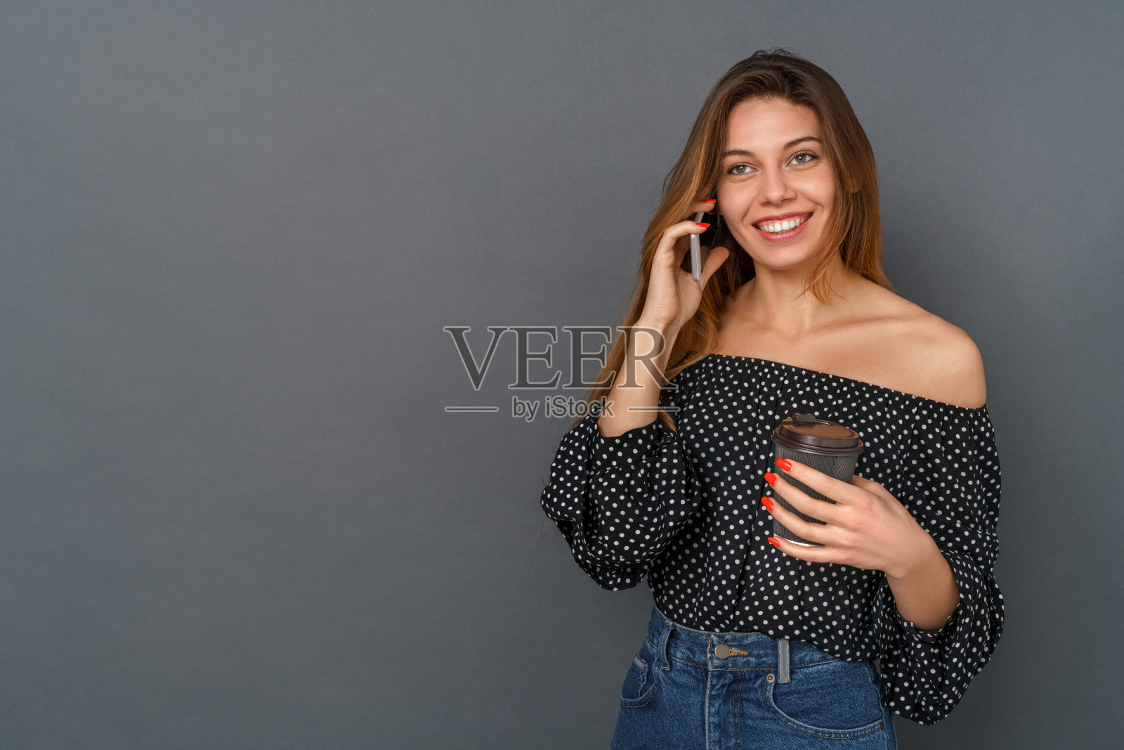 年轻女子休闲工作室孤立在灰色讲电话喝咖啡照片摄影图片