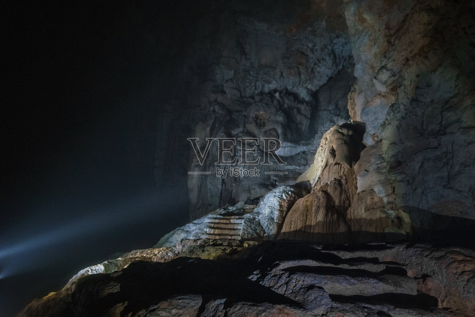 山洞里的楼梯被手电筒照亮了照片摄影图片