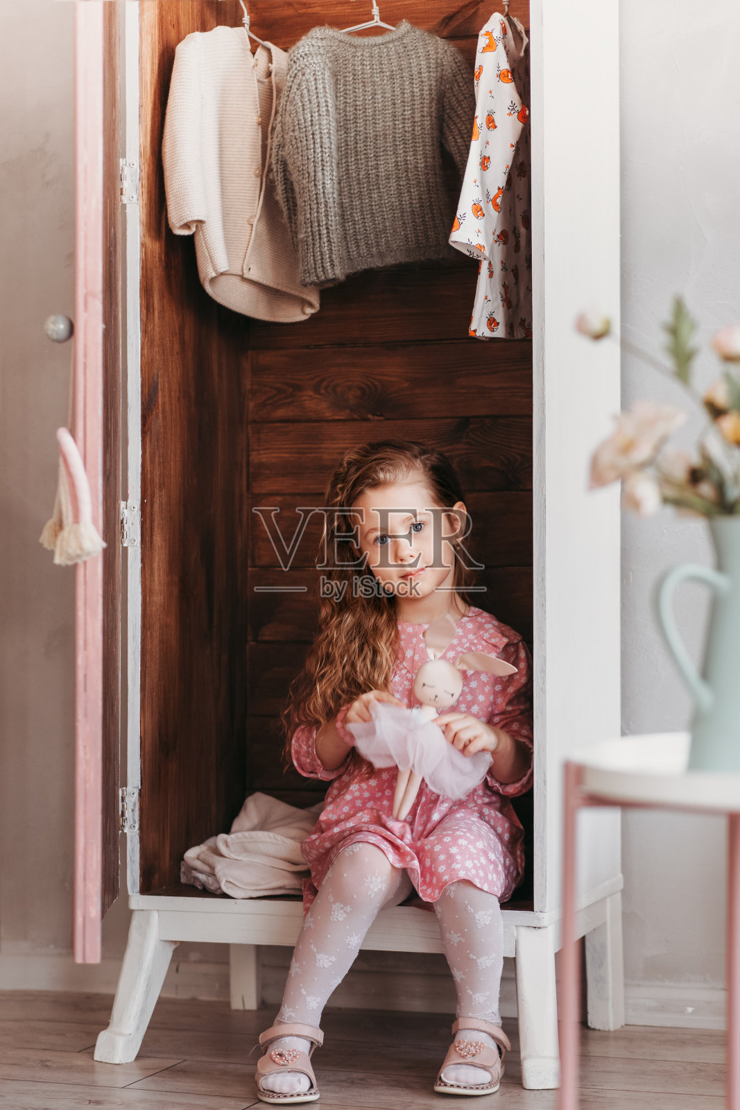一个小女孩坐在衣橱里放衣服照片摄影图片