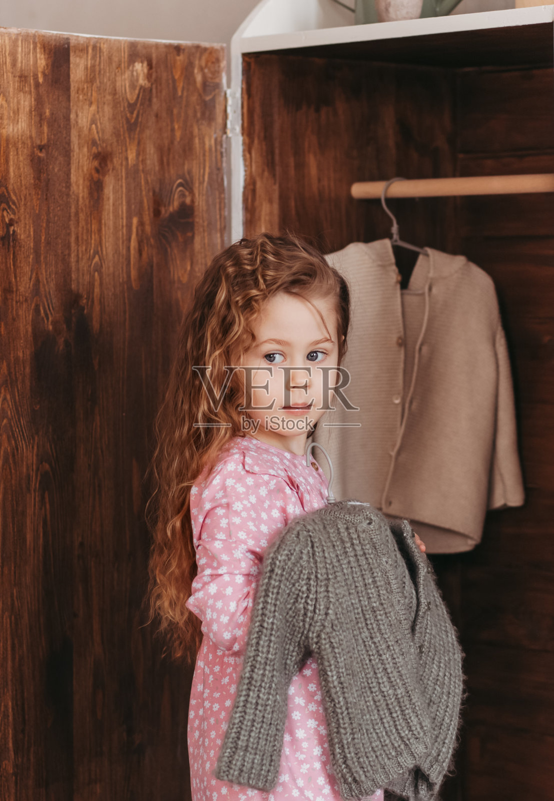 小女孩在壁橱里检查衣服照片摄影图片
