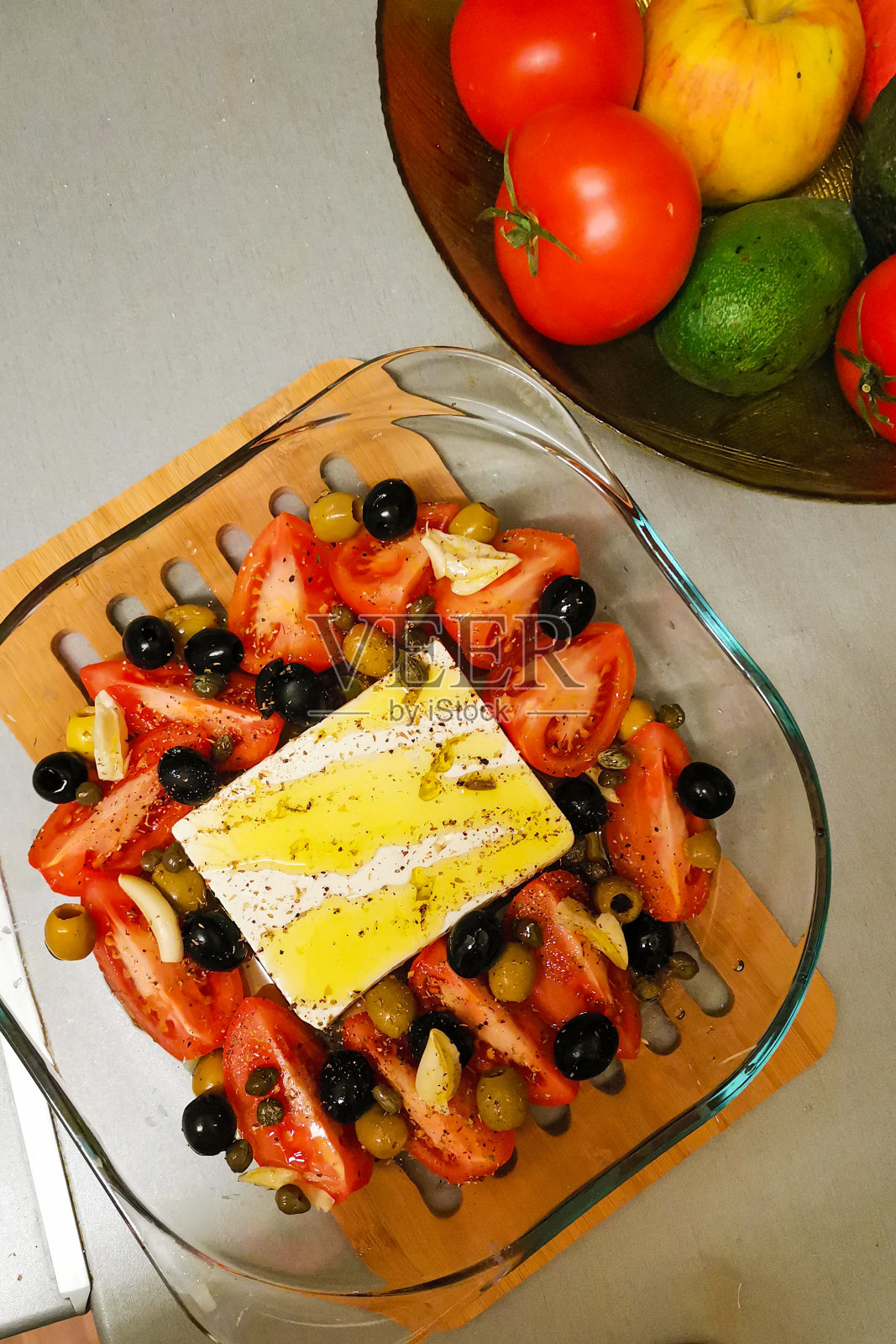 烤羊乳酪配西红柿，橄榄，酸豆和橄榄油照片摄影图片