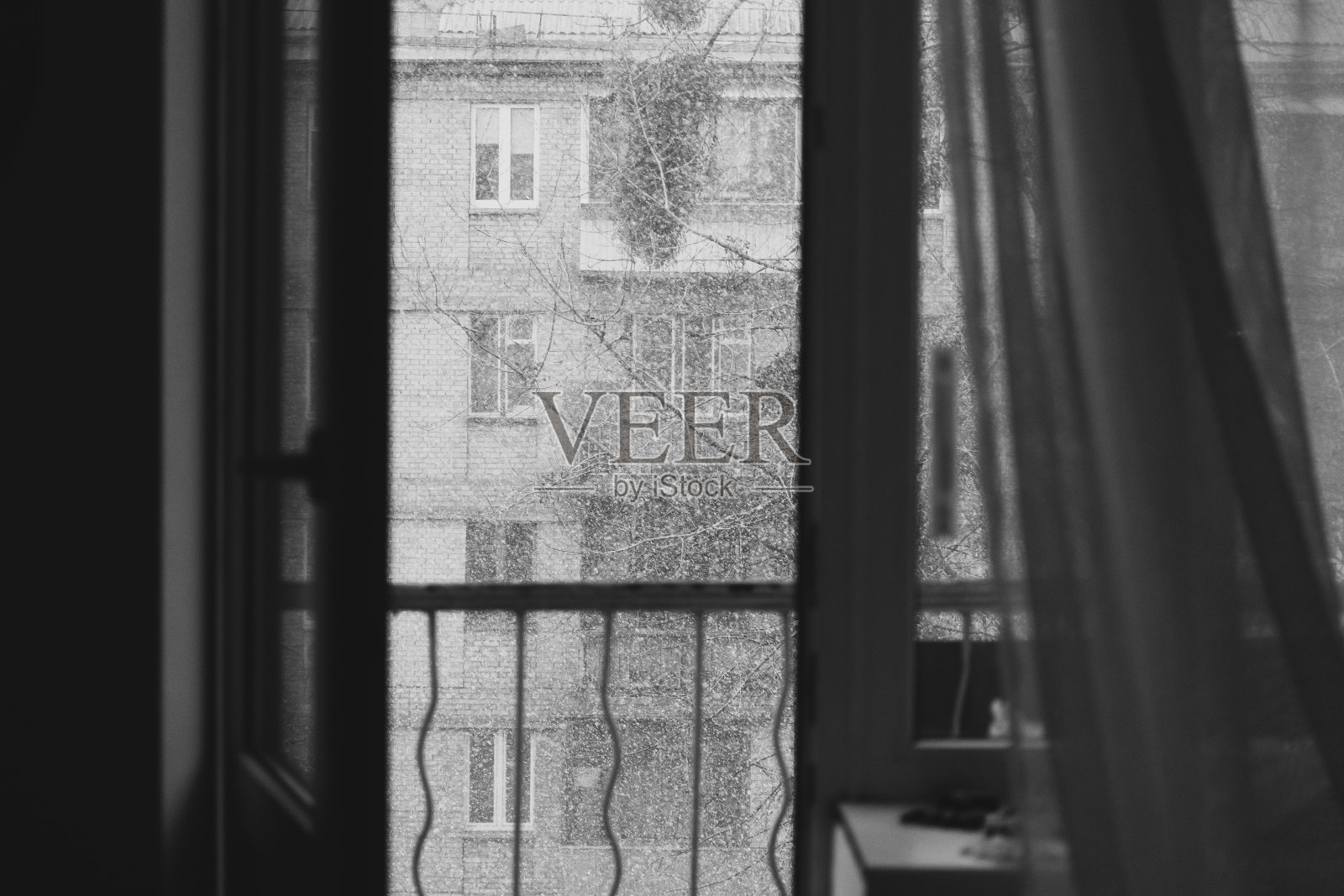 打开阳台门，在一个冬天的日子里下雪。照片摄影图片