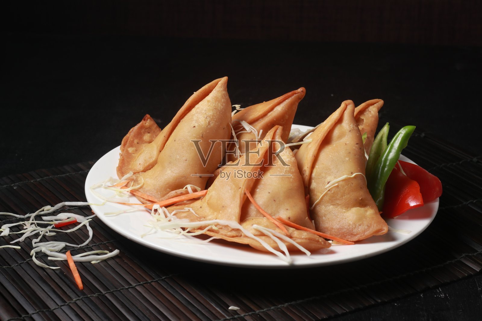 斋月特别的油炸食品，如开斋时的萨莫萨，春卷，卡乔里，新鲜蔬菜和酱汁照片摄影图片