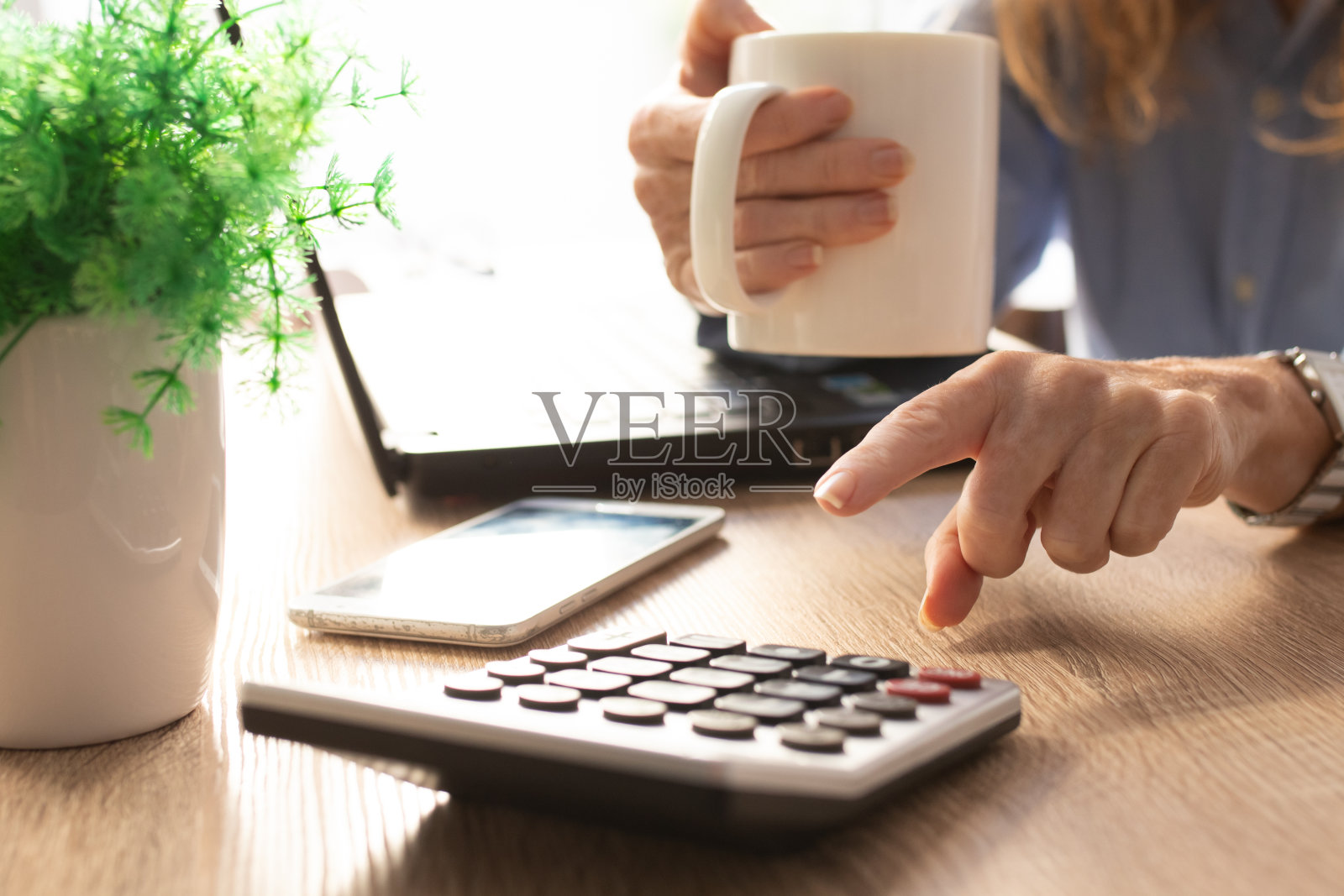 商务女性手拿计算器和手机照片摄影图片