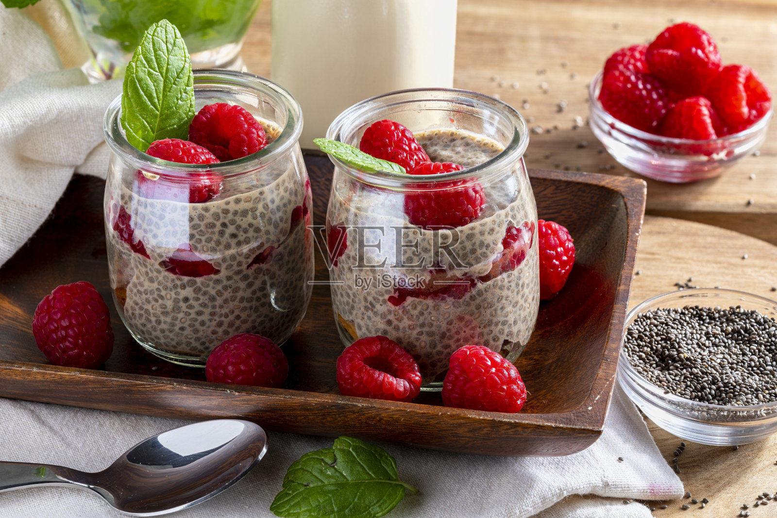 开胃，健康和清爽的奇亚种子布丁与新鲜的树莓，薄荷叶和饼干。素食和纯素食物与健康的超级食物。自制的看。照片摄影图片