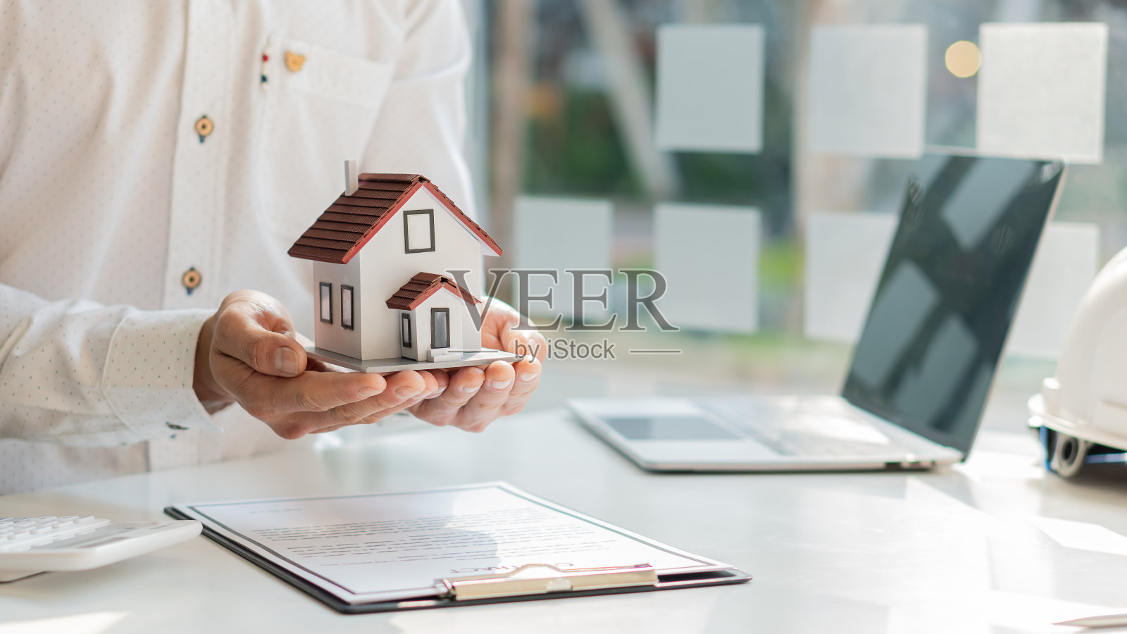 房地产经纪公司在办公室的桌子上出售和出租房子。照片摄影图片