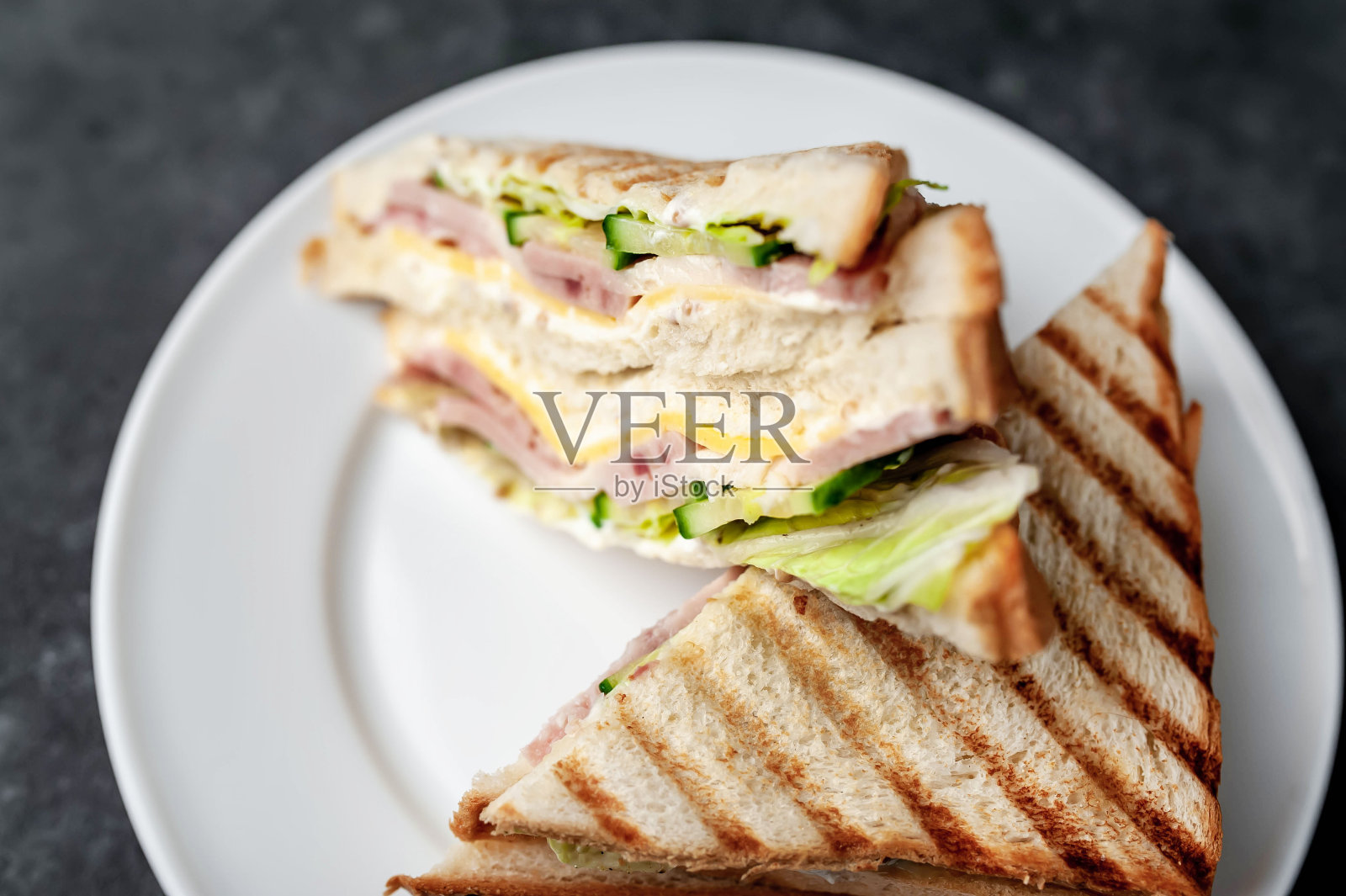 石头背景上的白色盘子上美味的三明治照片摄影图片