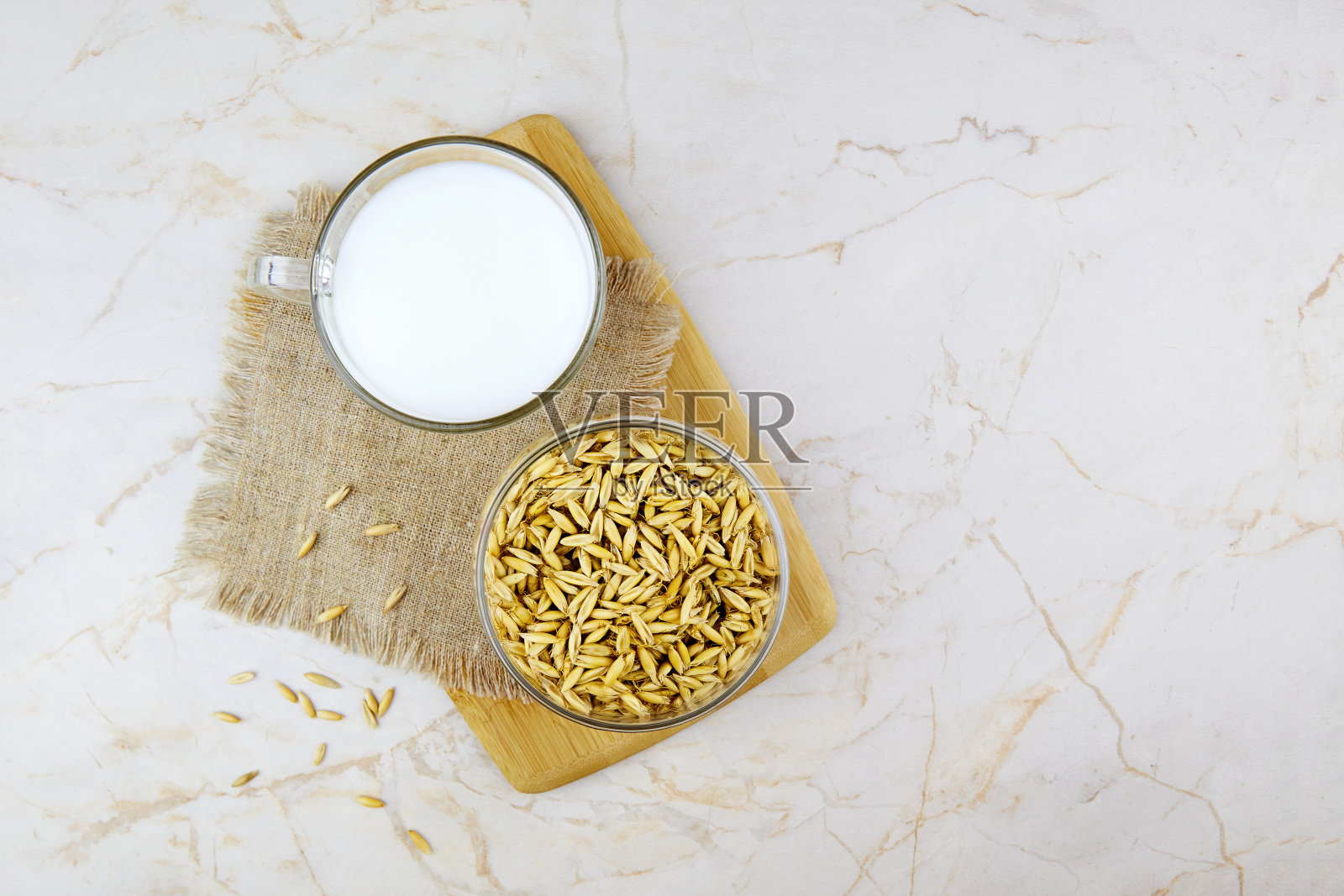 一杯燕麦，牛奶和燕麦放在一个罐子里。蔬菜牛奶。素食乳糖免费。照片摄影图片