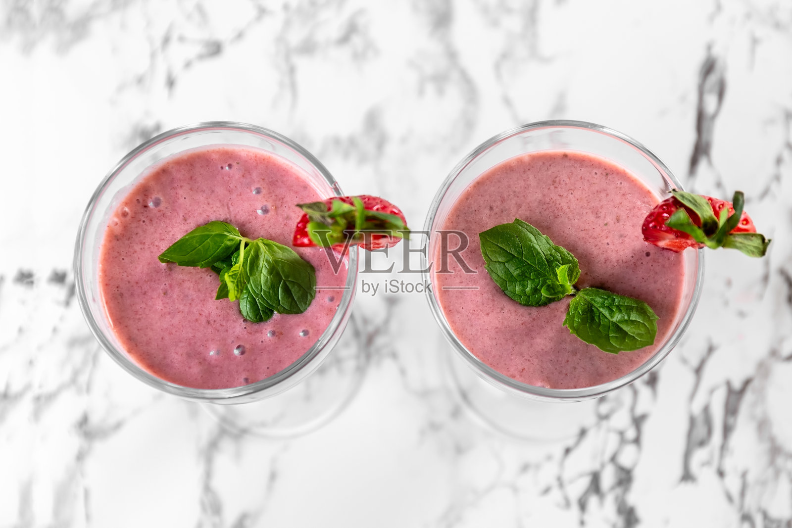 草莓香蕉奶昔。草莓甜点。浅灰色的背景。照片摄影图片