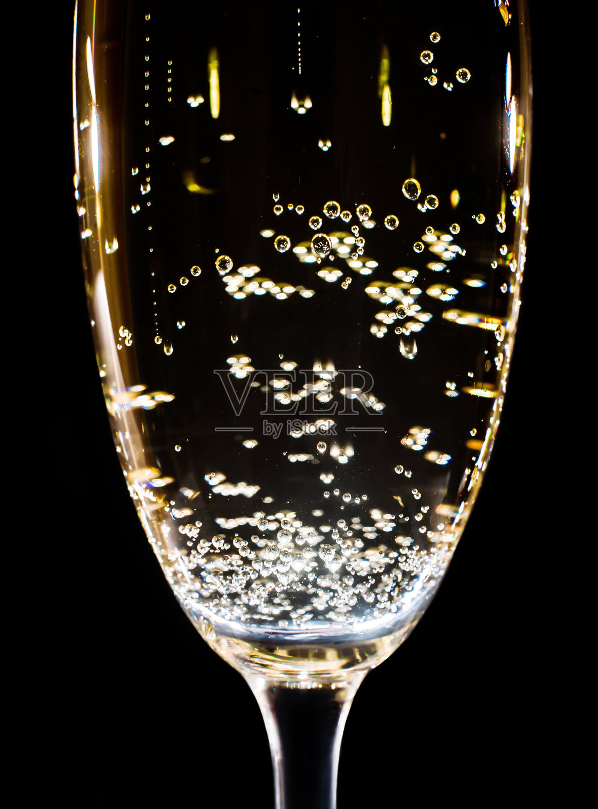 香槟与泡沫在一个黑色背景上的玻璃杯，特写照片摄影图片