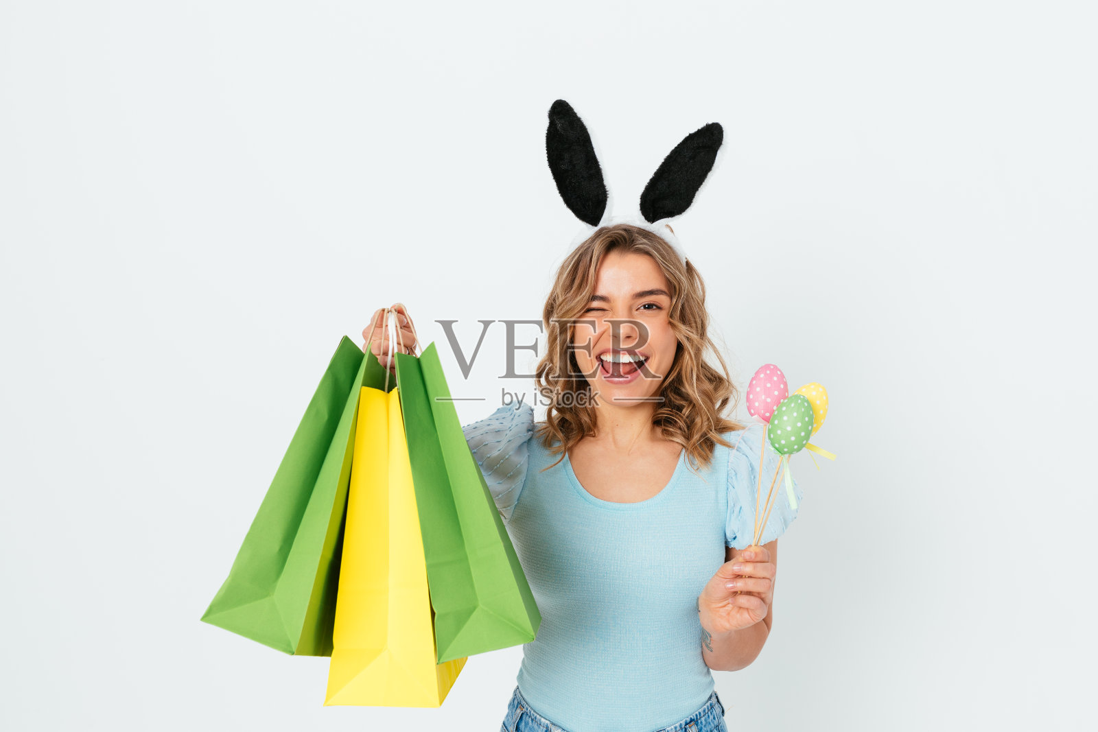 复活节购物时，年轻女子兴高采烈地戴着兔子耳朵微笑照片摄影图片