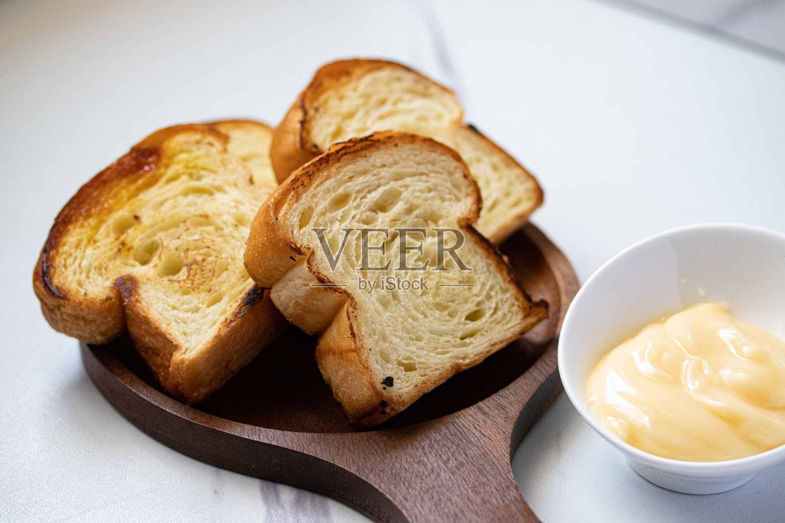 烤面包在木盘子和奶酪在灰色的背景照片摄影图片