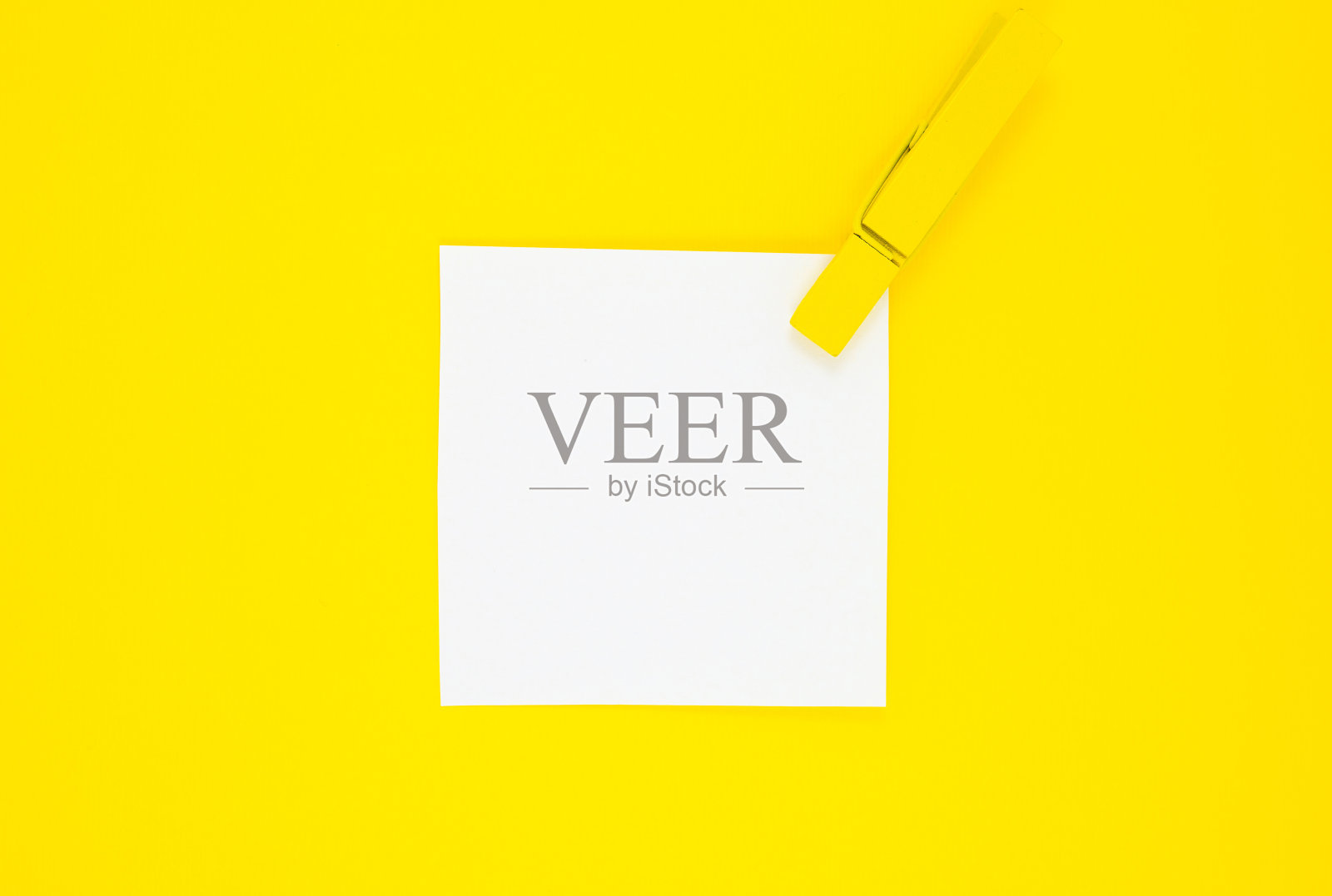 空白白色待做清单贴纸与黄色木制晾衣夹。在黄色背景上关闭提醒纸。副本的空间。极简主义，原创和创意的照片。照片摄影图片