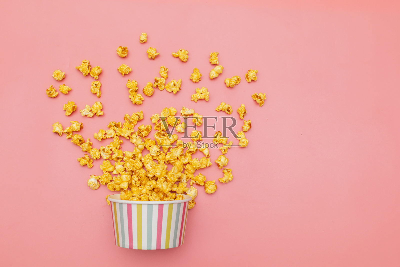 焦糖流行偶像在多色杯粉红背景照片摄影图片