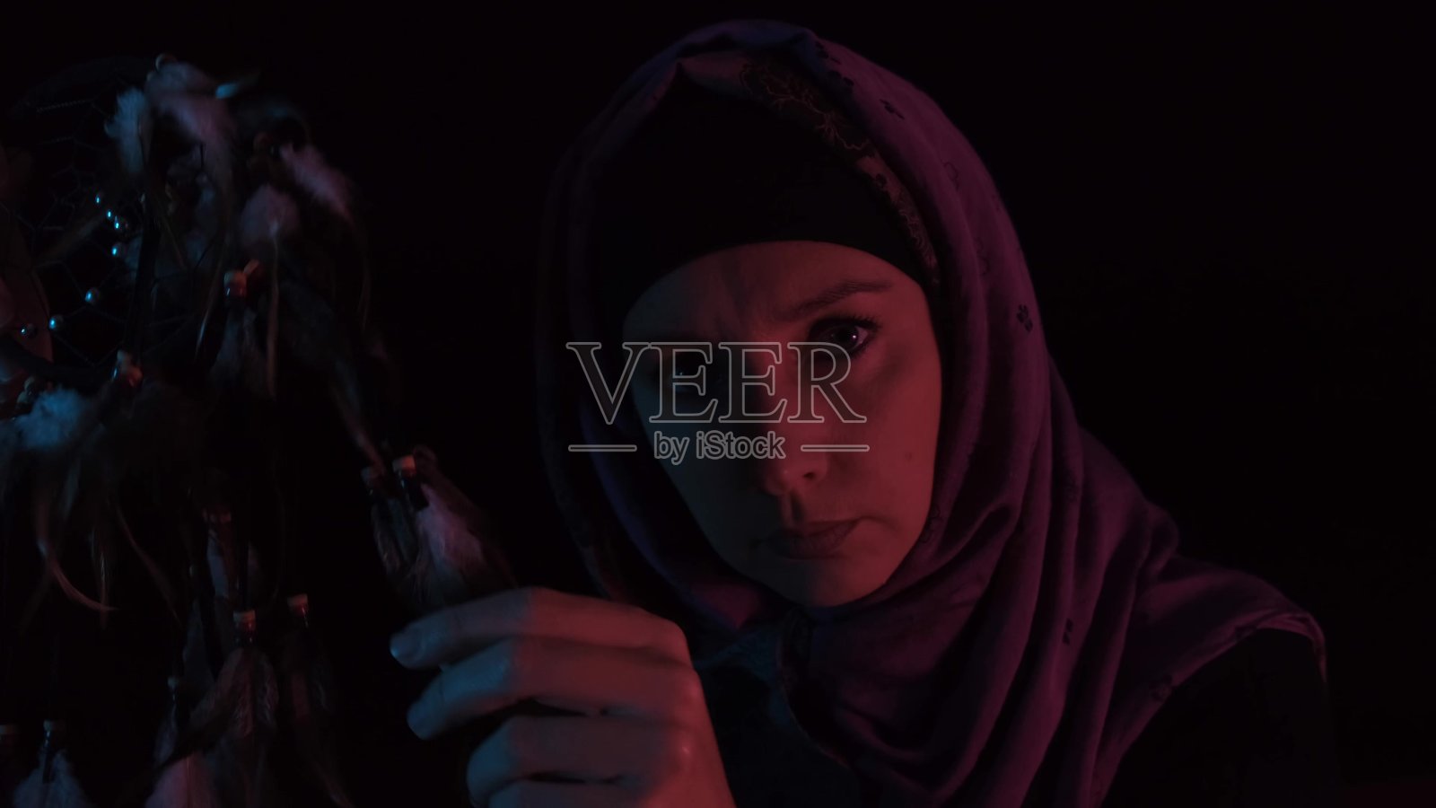 一个愤怒的女巫在黑暗的夜里用羽毛施展巫术和咒语照片摄影图片