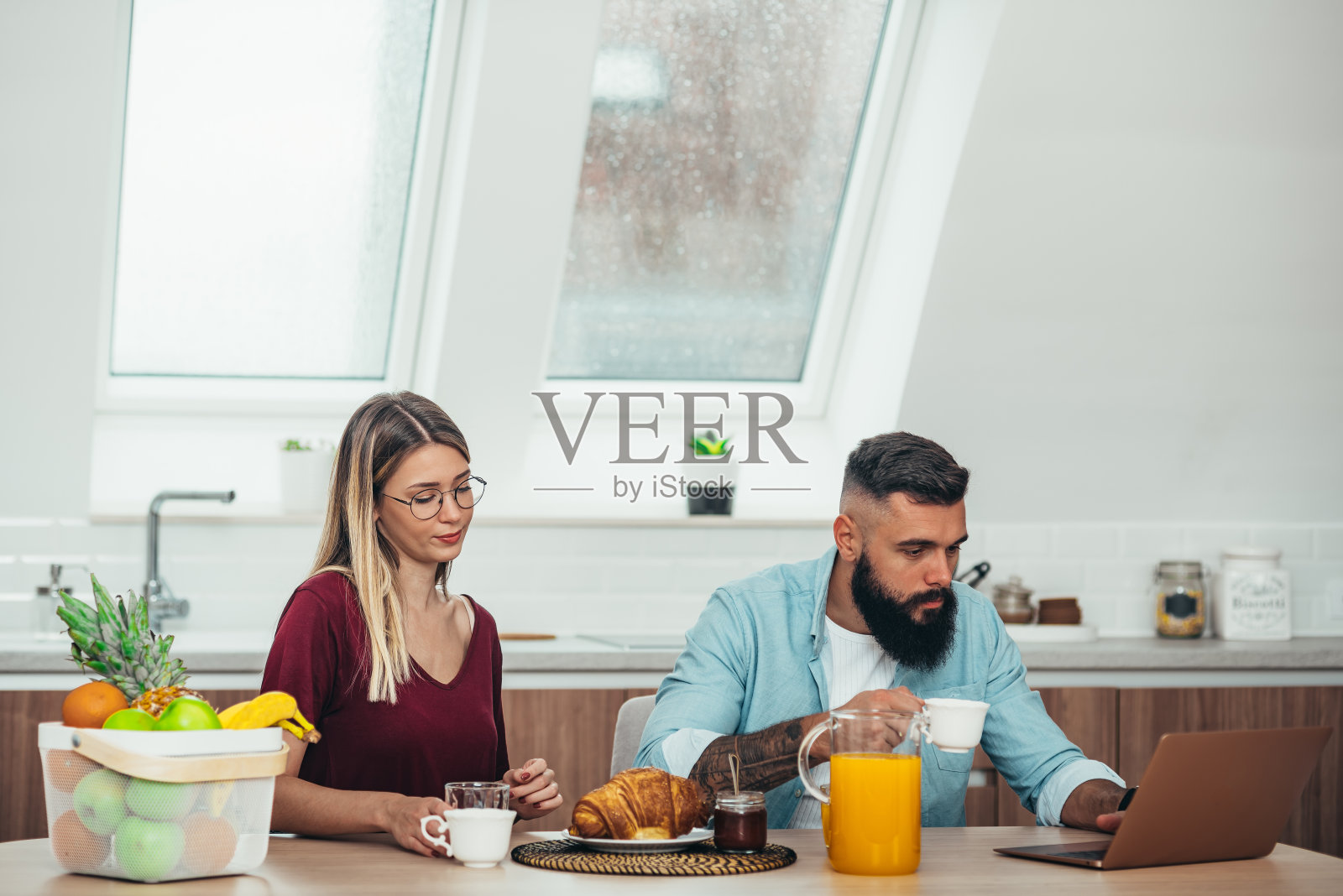 夫妇在家里吃早餐时使用笔记本电脑照片摄影图片