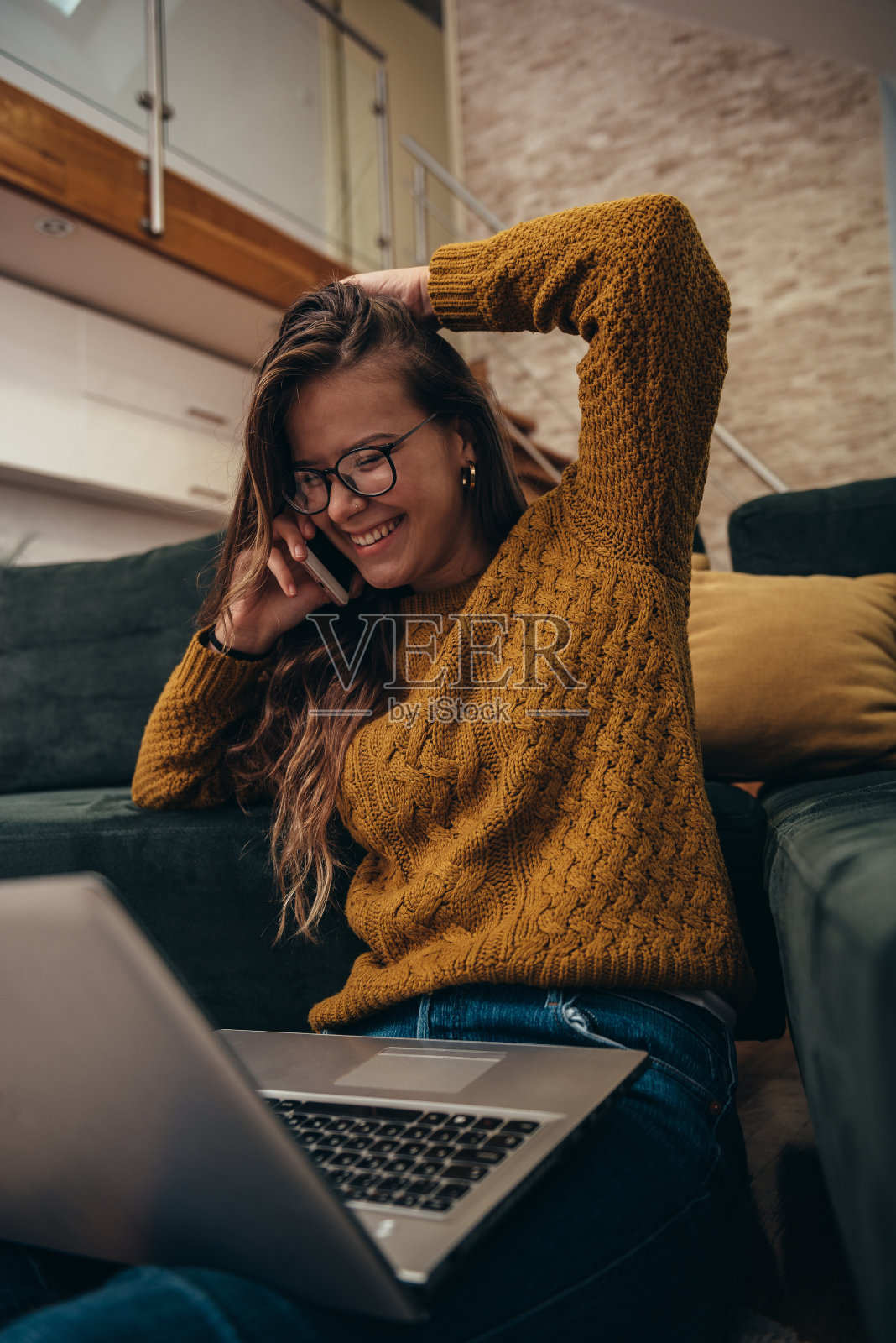 在家工作时使用笔记本电脑和智能手机的女性照片摄影图片